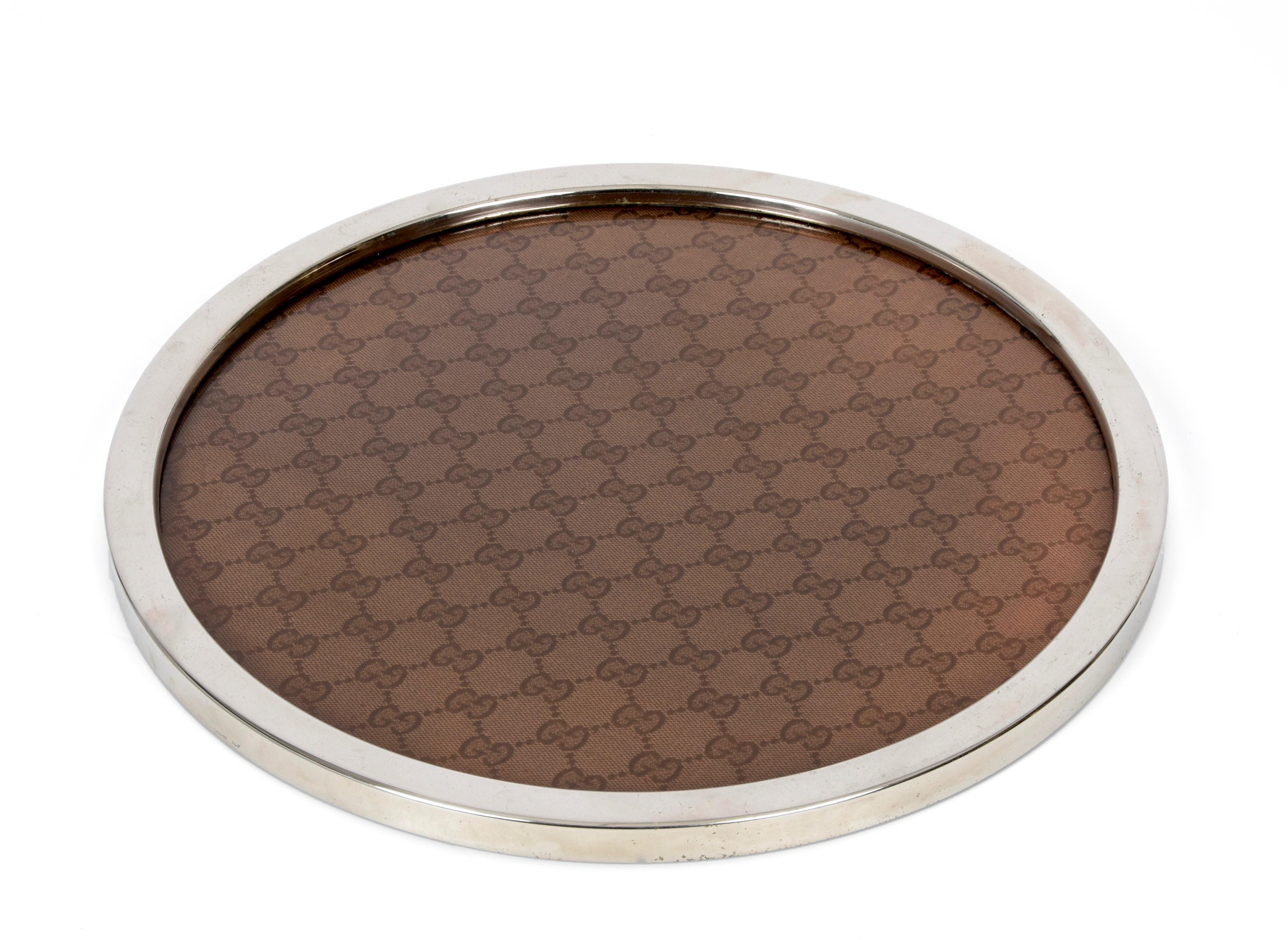Iconic midcentury silvered metal, brown fabric and lucite tray. This astonishing piece was produced in Italy in 1969 by Gucci. 

The Gucci logo is clearly visible on the base of the tray and the words 