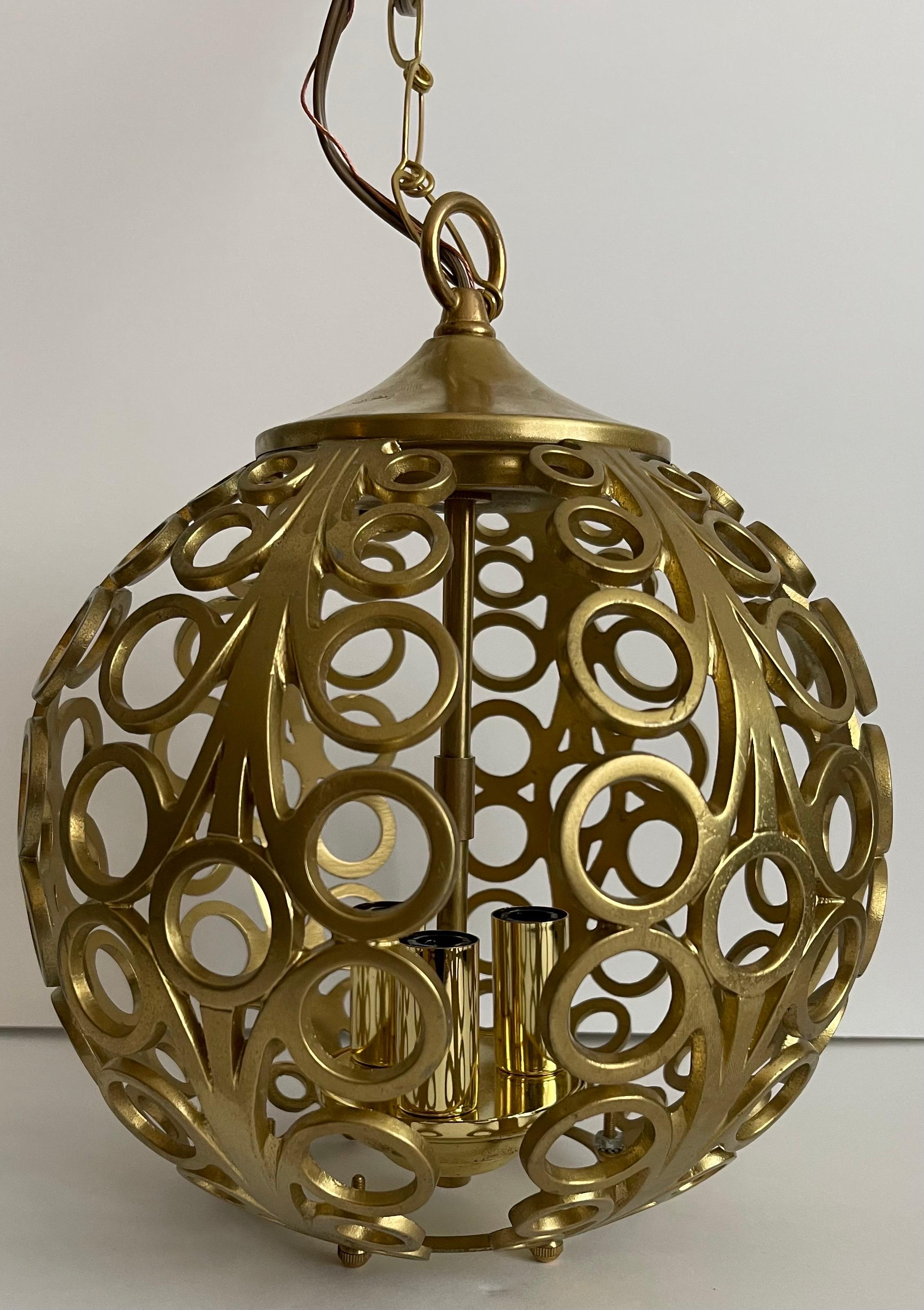 1960s Pierced gold metal pendant light. As found painted gold finish. Newly rewired. Fixture takes three chandelier bulbs (not included). 36” L chain and brass canopy included.
