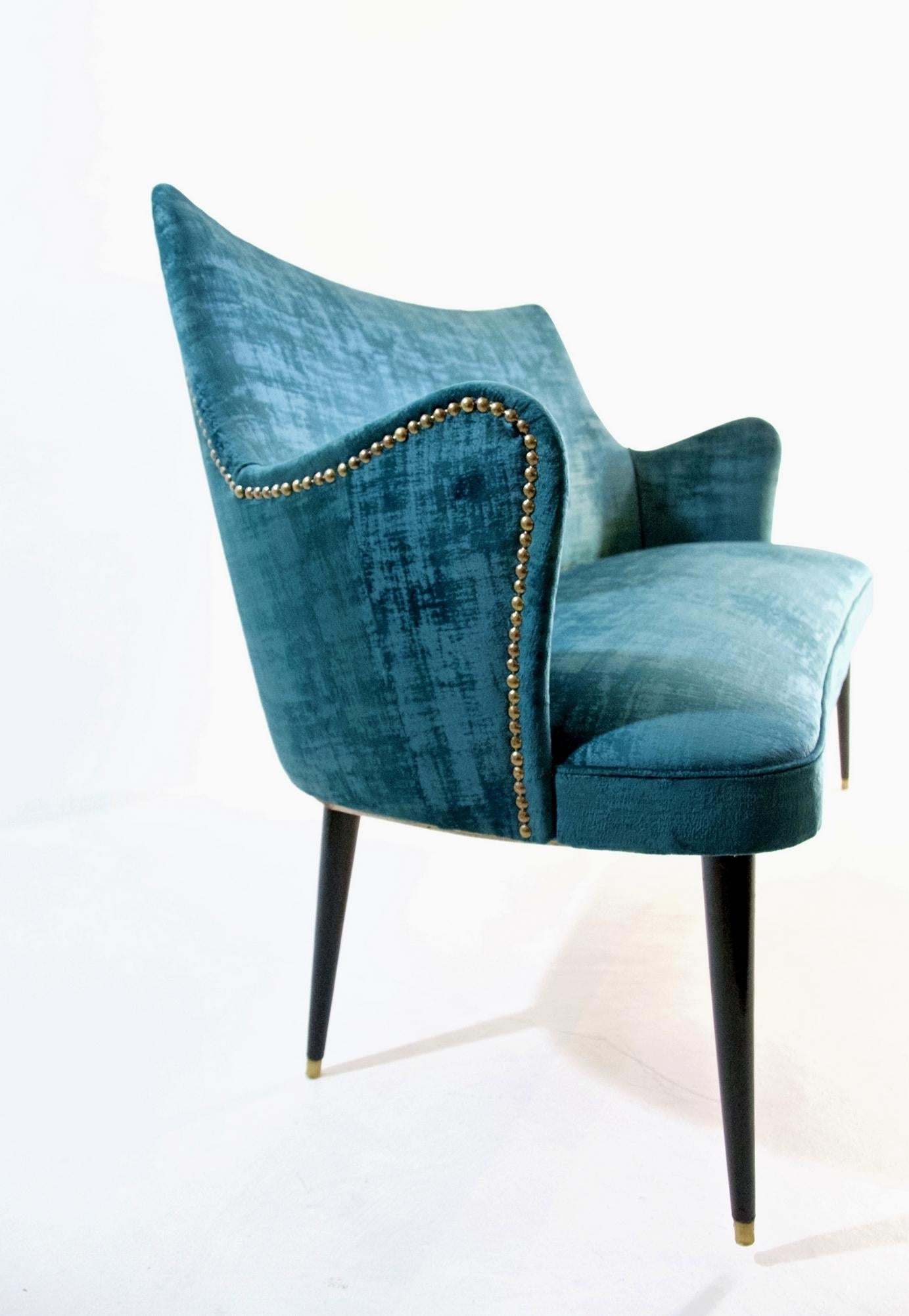 This sofa which is very rare was designed by Osvaldo Borsani in the 1950s and has been professionally restored and reupholstered. The fabric used is a high quality strong teal colored velvet and is easy to remove stains from. It has stained and