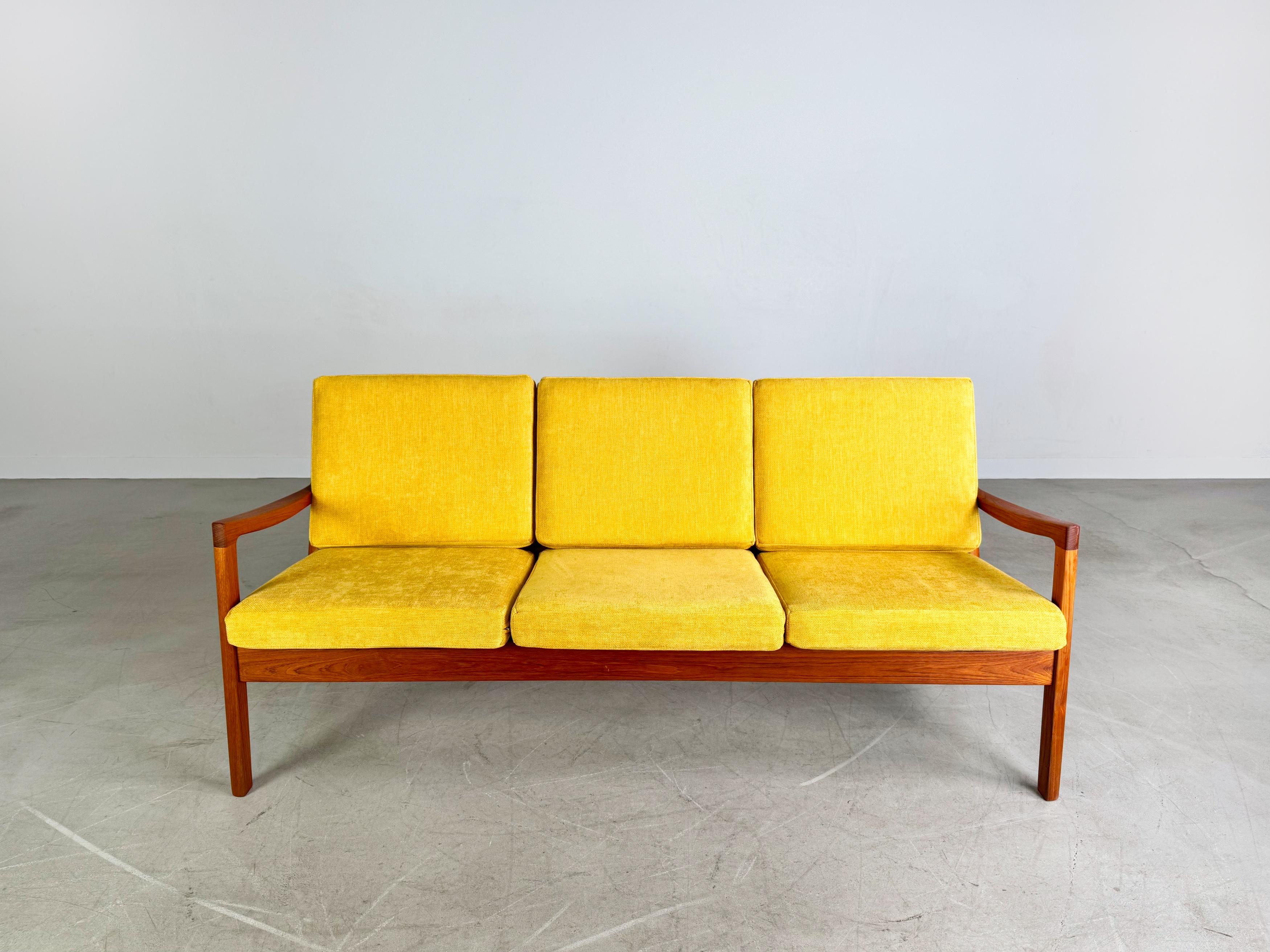 Wir bieten ein wunderschönes Teakholz Dreisitzer Sofa von France & Son aus den 1960er Jahren zum Verkauf an. Das Möbel besticht durch seine minimalistische Formgebung, wurde professionell aufgearbeitet und erhielt einen neuen, maßgeschneiderten