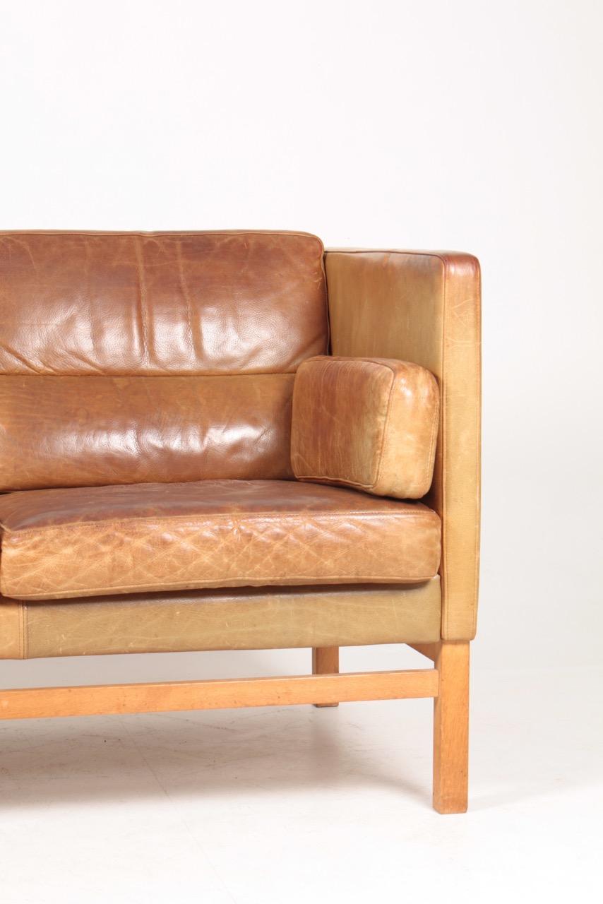 Three-seat sofa in patinated leather designed and made in the 1960s. Original condition. Made in Denmark.