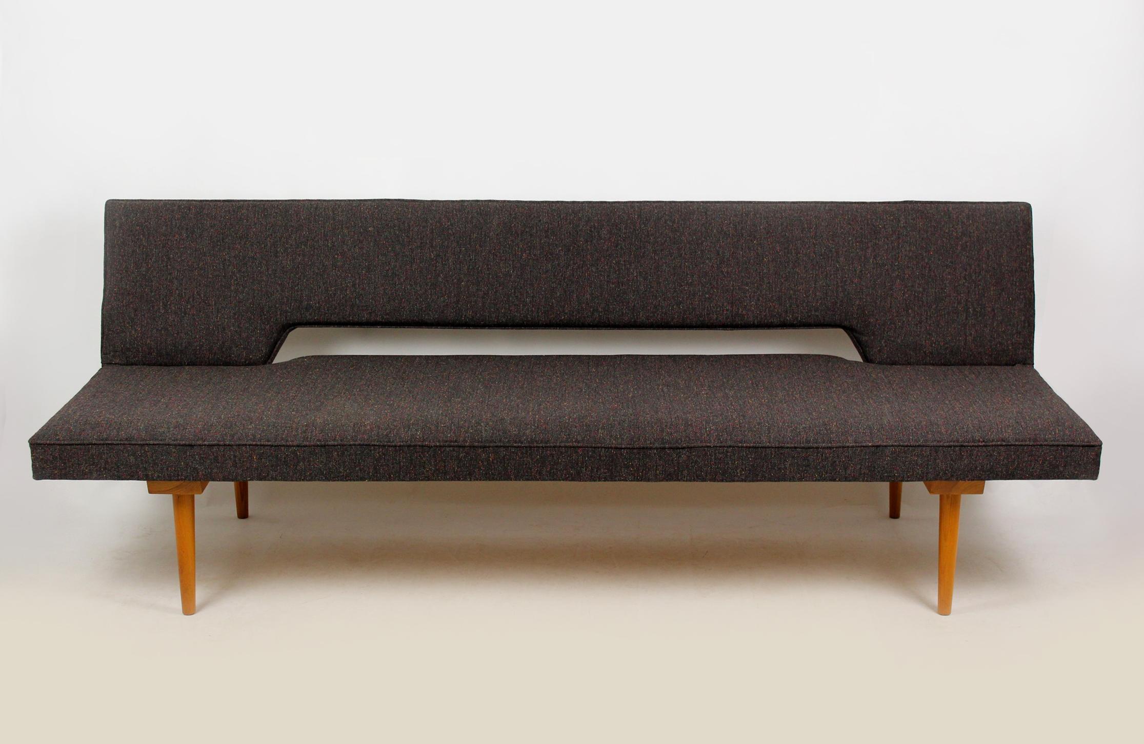 Midcentury sofa in a simple, minimalistic form. Designed by Miroslav Navratil in the 1960s/1970s. The couch simply converts into a daybed (195x85cm). Completely restored – woodwork has been refinished in satin, pillows have been upholstered with new
