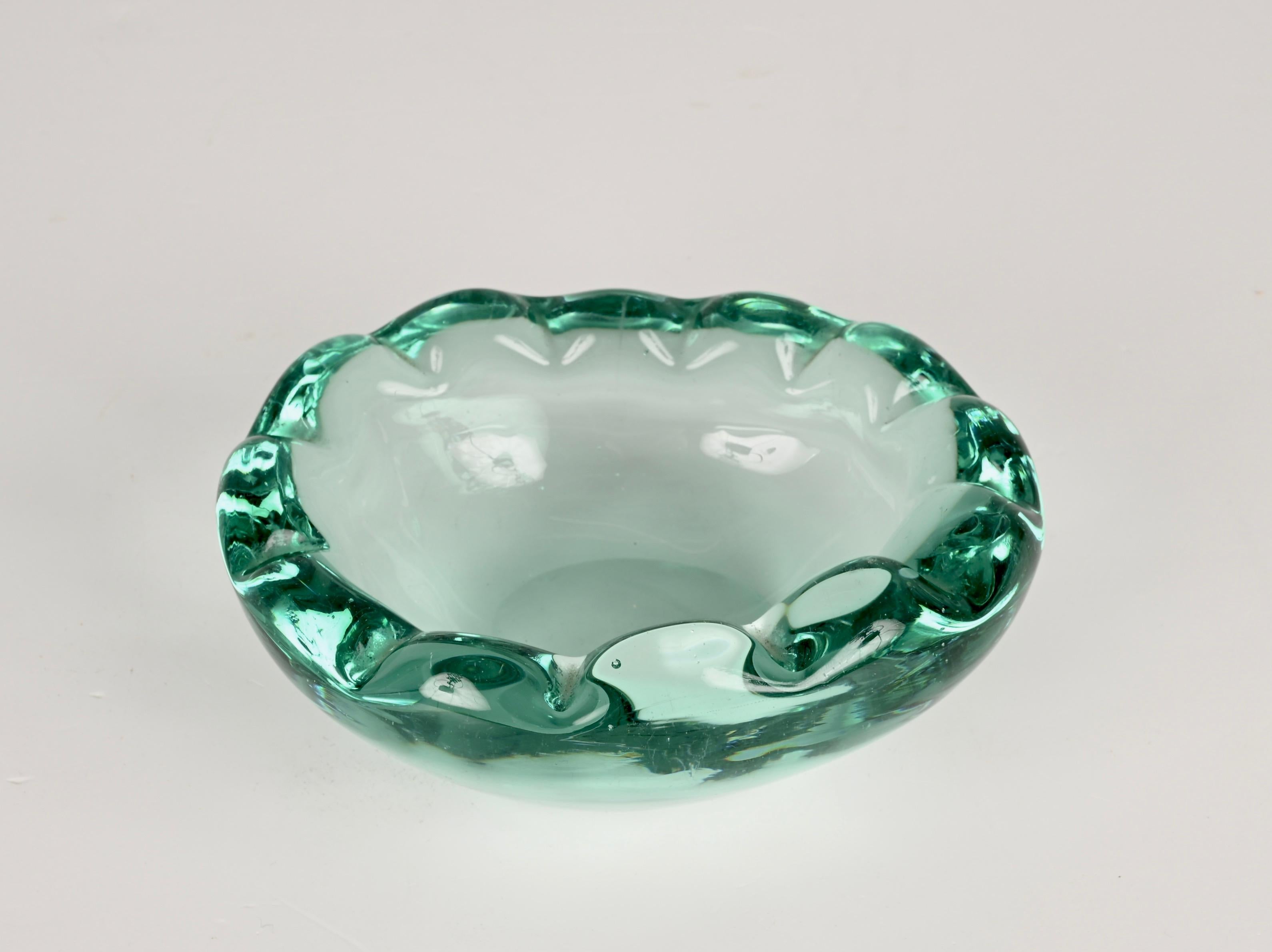 Wonderful mid-century sommerso Murano crystal green glass decorative bowl or ashtray. This magnificent piece was produced in Italy during the 1960s.

This centrepiece is unique thanks to the clean way in which the piece was designed and the purity