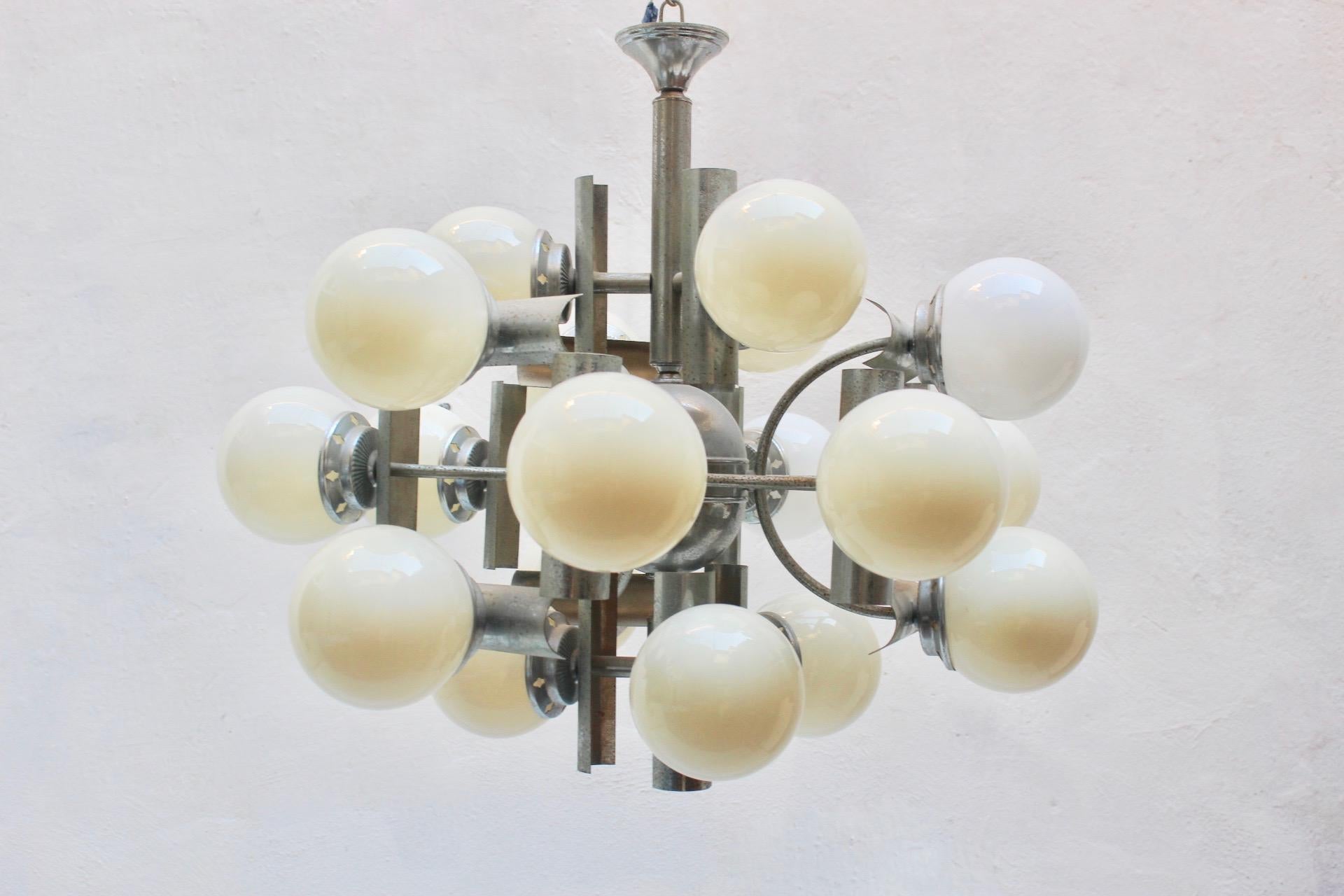Midcentury Space Age 18 lights Chandelier. Spain, 1960s.
Most of te glass globes are original from age and they have a kind of brown/yellow patina/wear which gives this yellow/amber ambient, but 2 are new and they have a different white