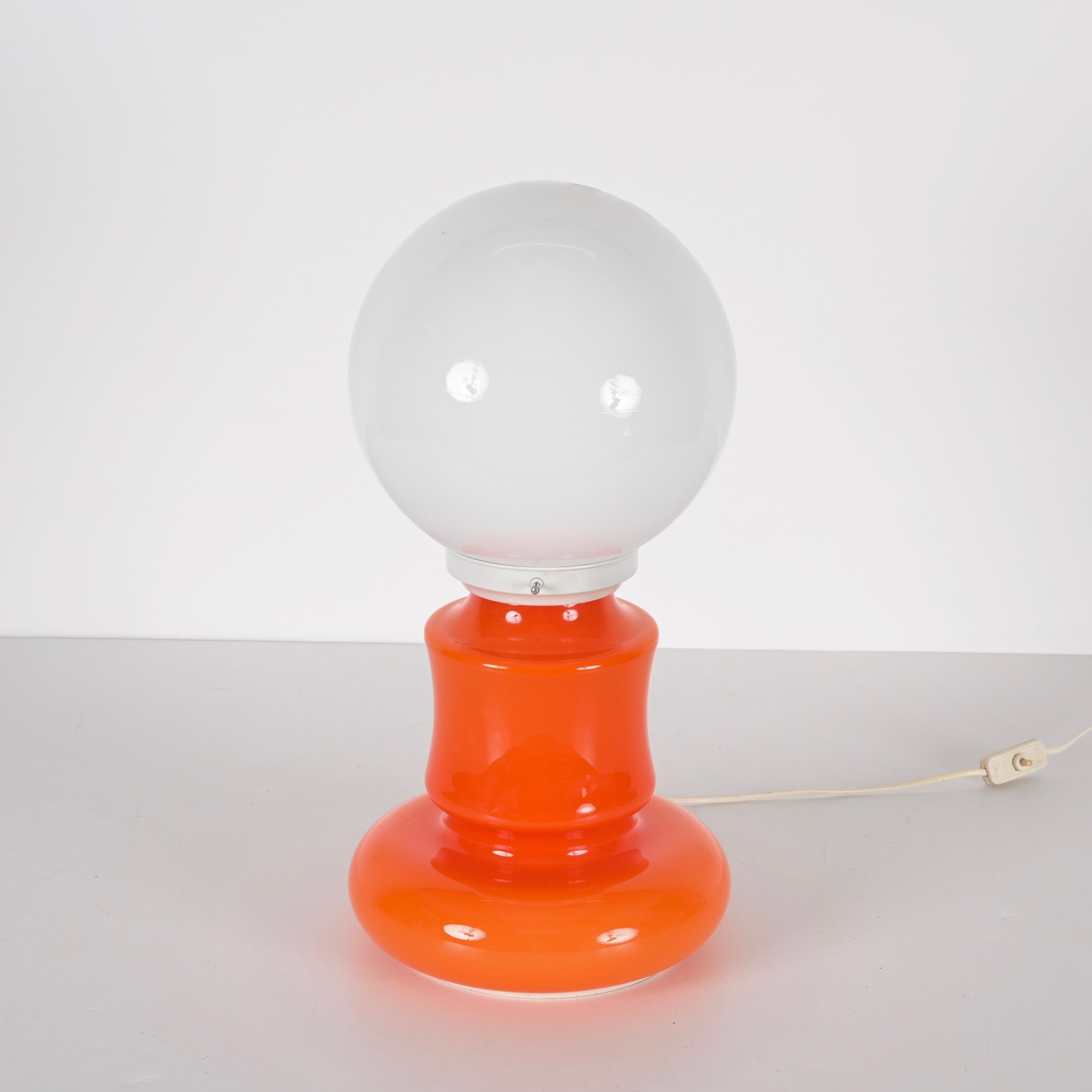 Amazing mid-century space age orange and white Murano glass table lamp. This fantastic piece was designed in Venice, Italy, during the 1970s.

This item is astonishing as the artistic Murano glass is used for the bulb cover and the lamp's