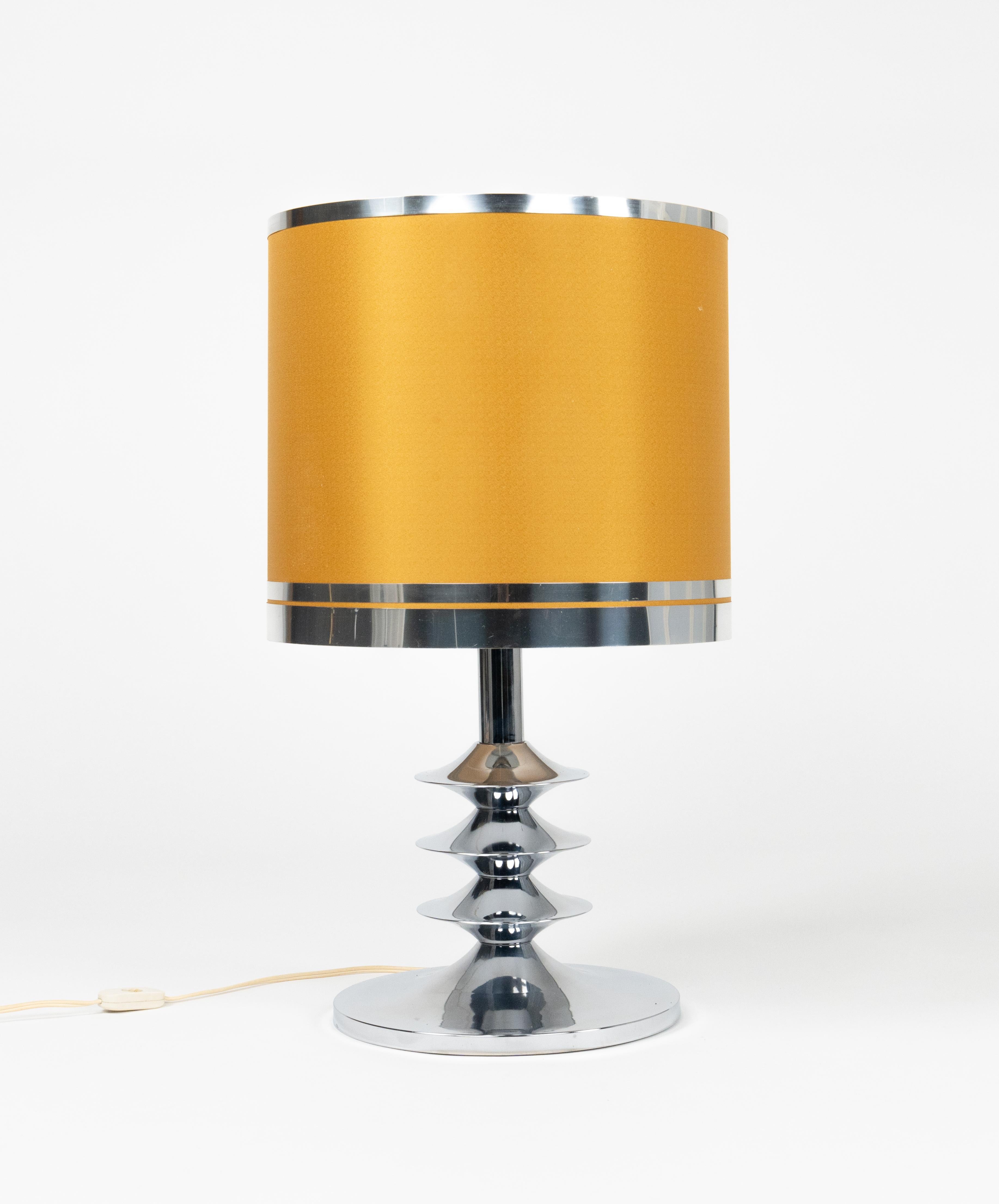 Midcentury space age belle lampe de table en chrome avec abat-jour en tissu.

Fabriqué en Italie dans les années 1970.

Il utilise 1 ampoule. 