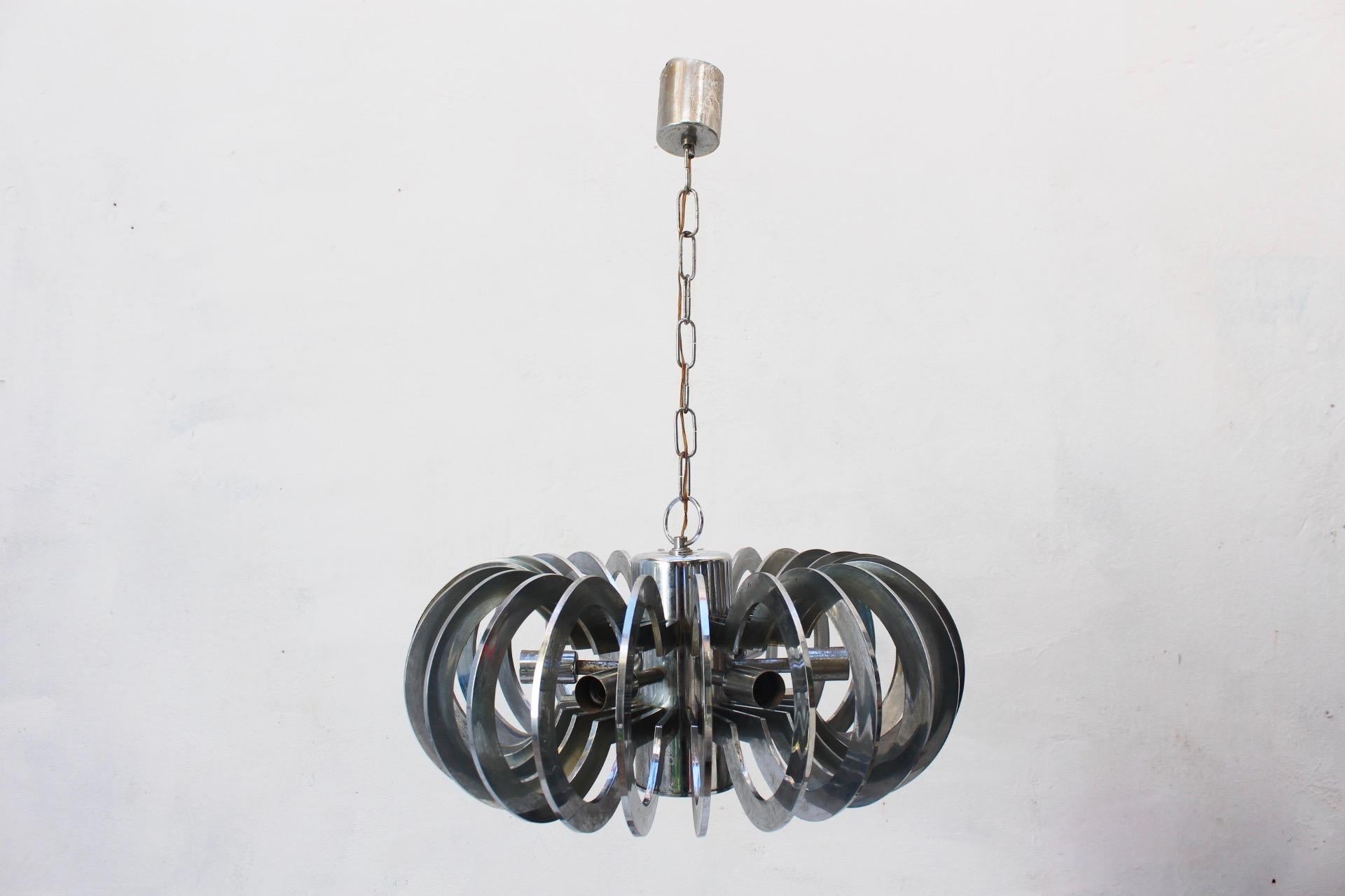 Rare to find, midcentury Ufo Space Age Atomic Era Pendant Lamp, Spain, 1960s. Central body made from chromed metal and r plastic concentric rings.
It use 6 bulbs, model E14.
It reminds somehow, the Iconic 