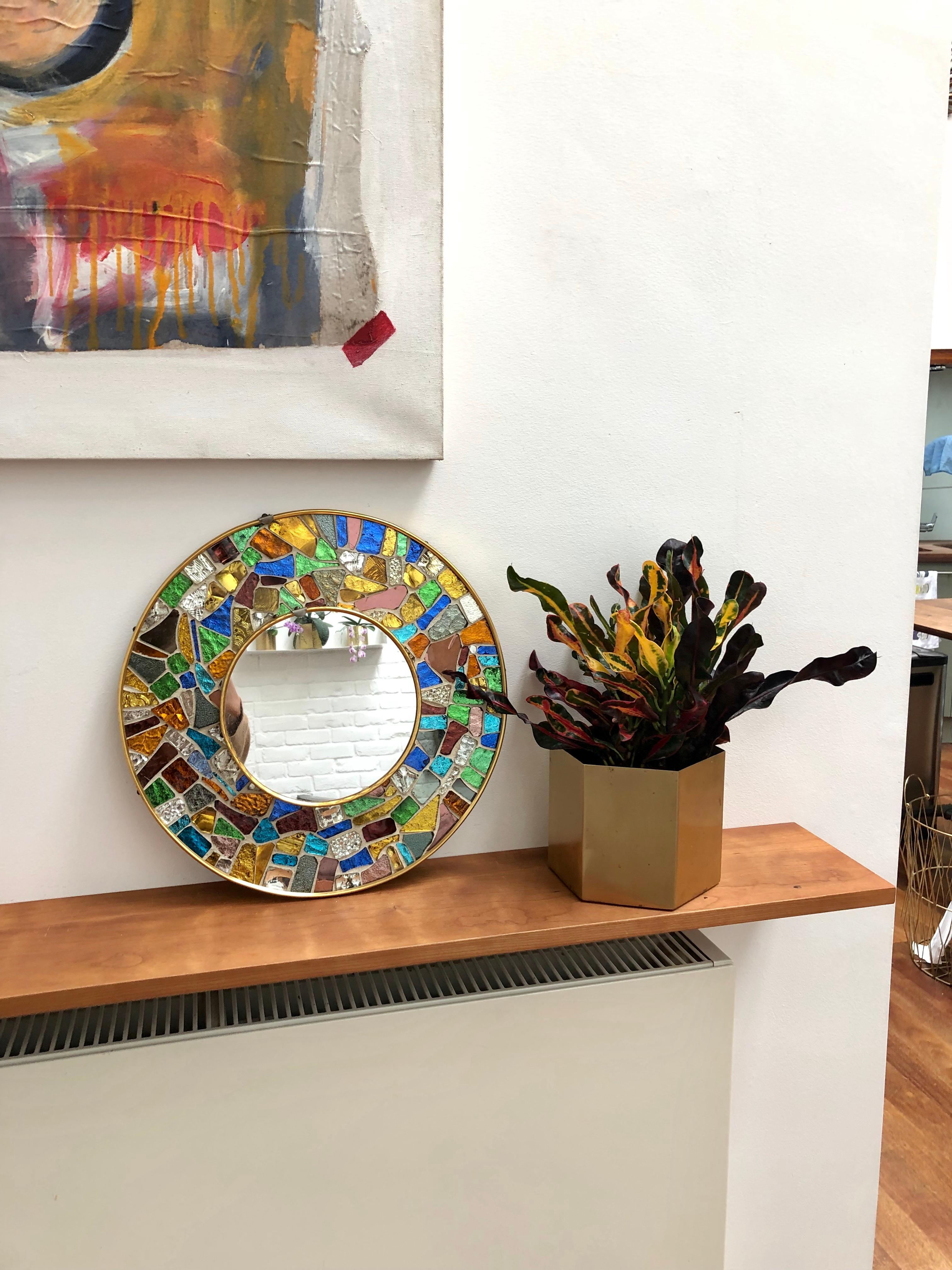 Vibrant midcentury circular decorative brass mirror with colourful mosaic surround. Made in the style of Antoni Gaudí's 'Trencadís' technique involving irregularly-shaped handcut-glass tiles in different colours. Spanish origin, circa 1960s. Short