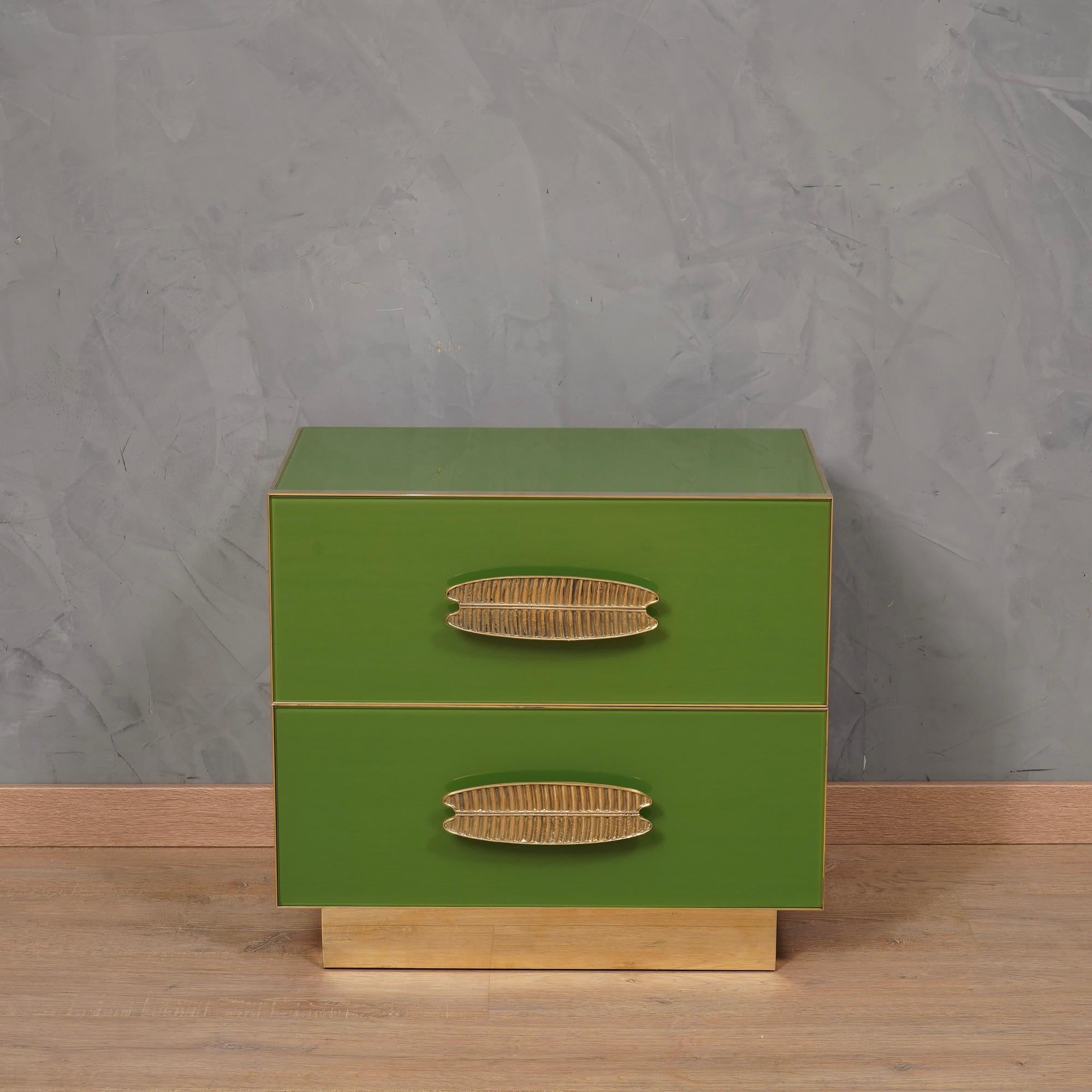 Classic design for a pair of night tables all in green colored glass and brass. Square and linear as in the style of that period.

The bedside tables have a wooden structure, above they have been covered with green colored glass; its precise hue