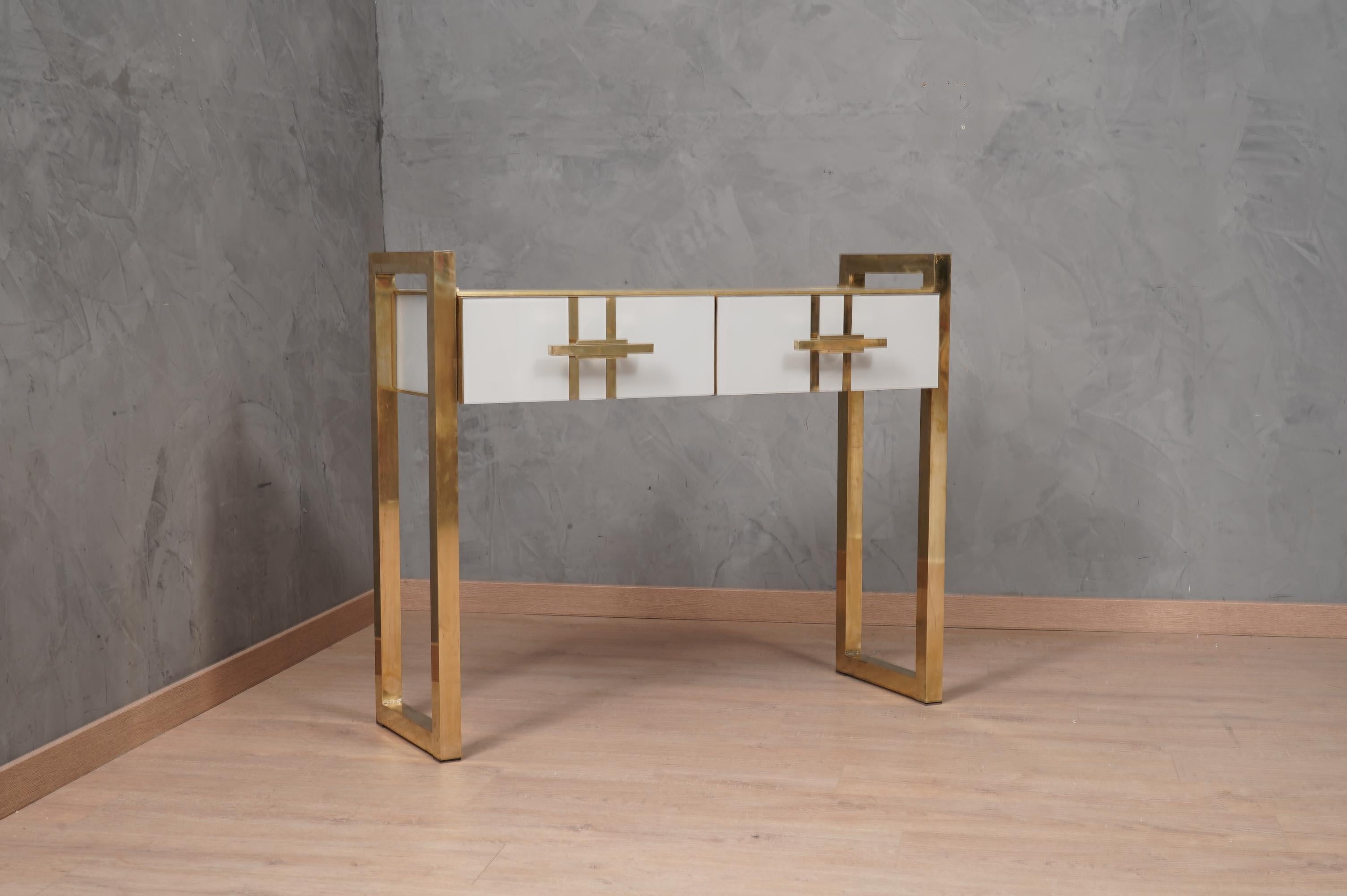 A unique console table of its kind for its originality and for the choice of materials. Simple but refined design. Note the rich workmanship of sides and drawers, with ground white glass squares interspaced with brass rods.

The console is composed