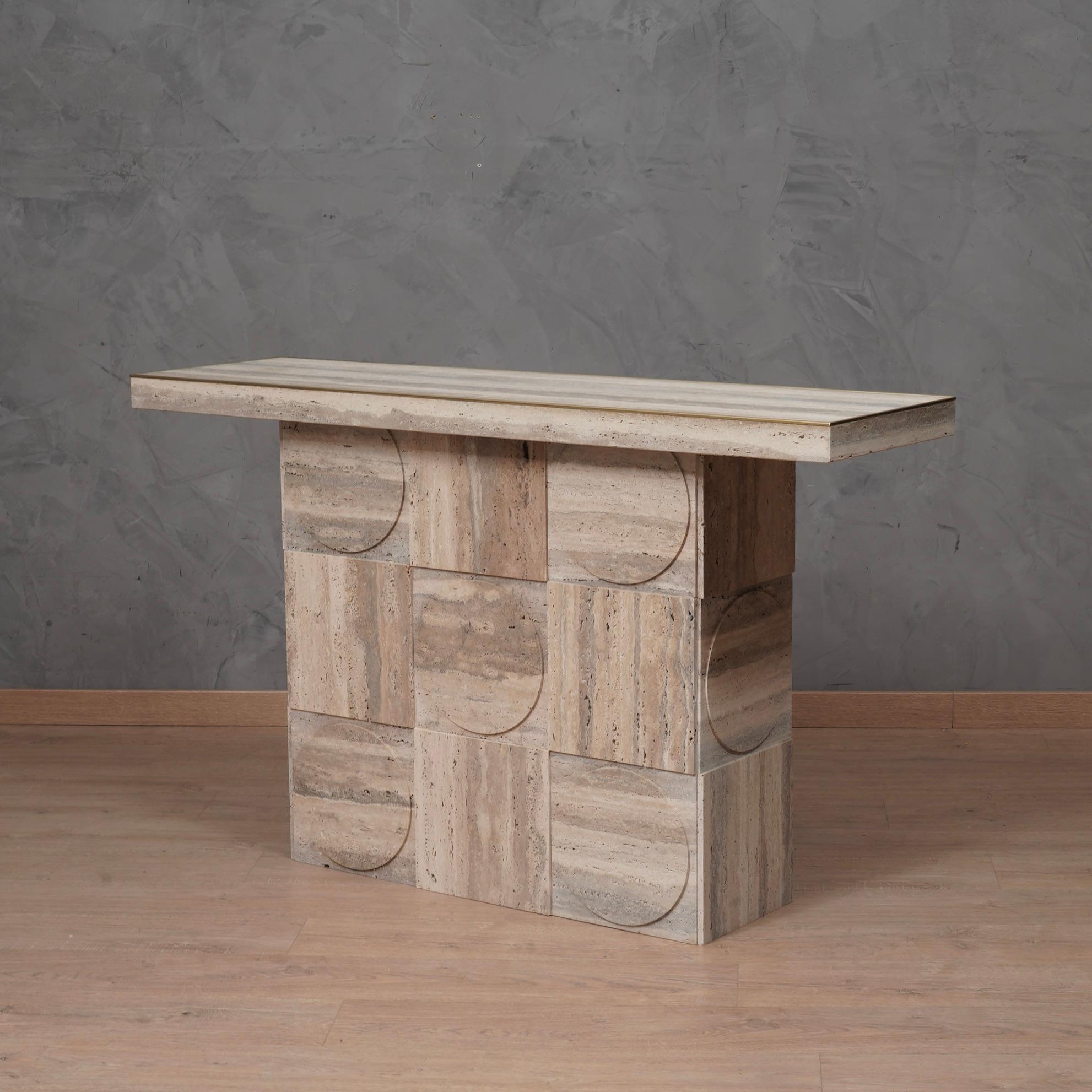 Console with a linear and stylish design, a beautiful sculpture also due to the union of two completely different materials such as travertine and brass.

The console is made up of a smooth travertine top with moldings along the perimeter of the