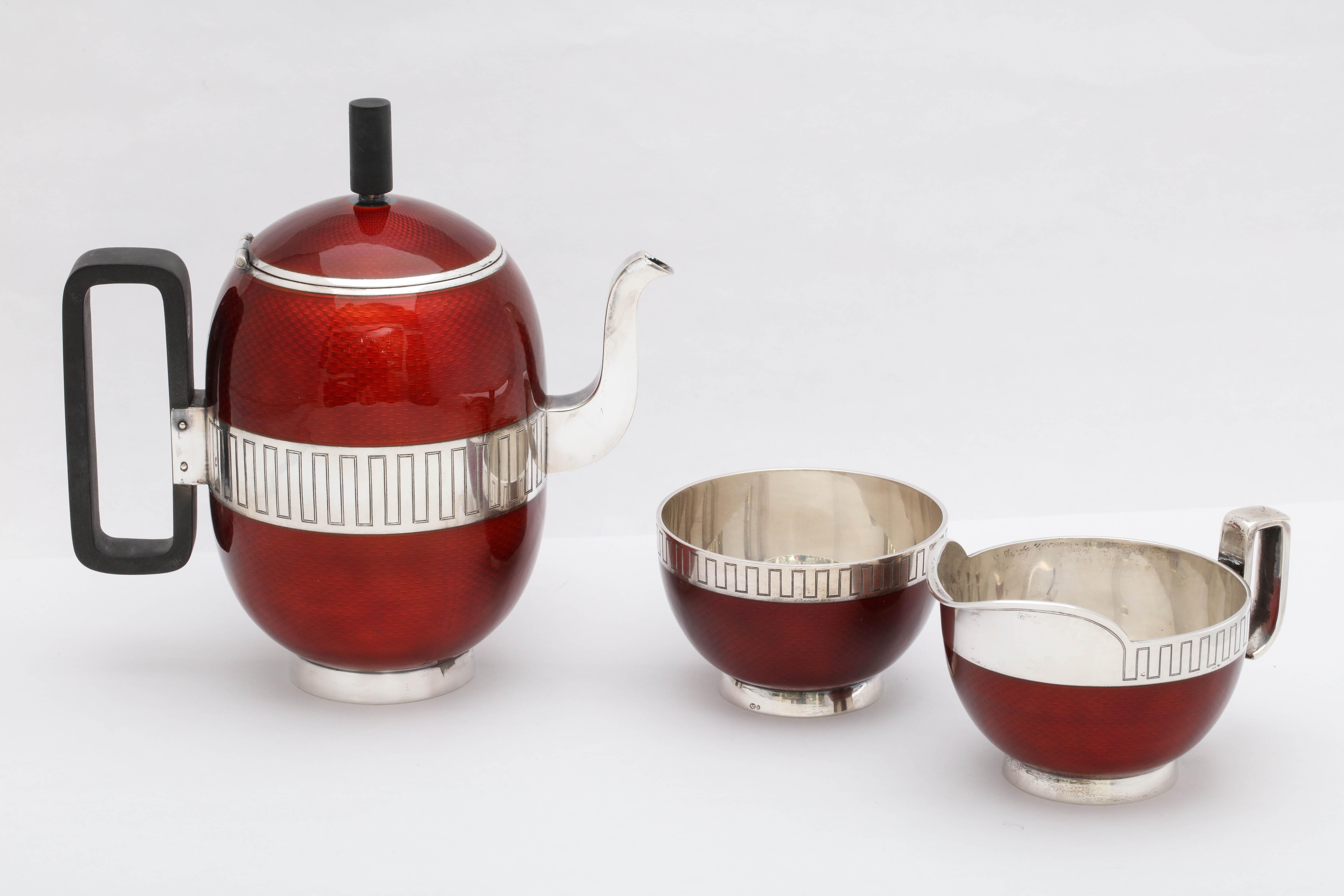 Mid-Century Modern, sterling silver and red guilloche enamel, three-piece demitasse set, the coffee pot having a wood handle and wood finial, Norway, circa 1950, David Andersen, maker. Some of the sterling is designed with a Greek Key design (see