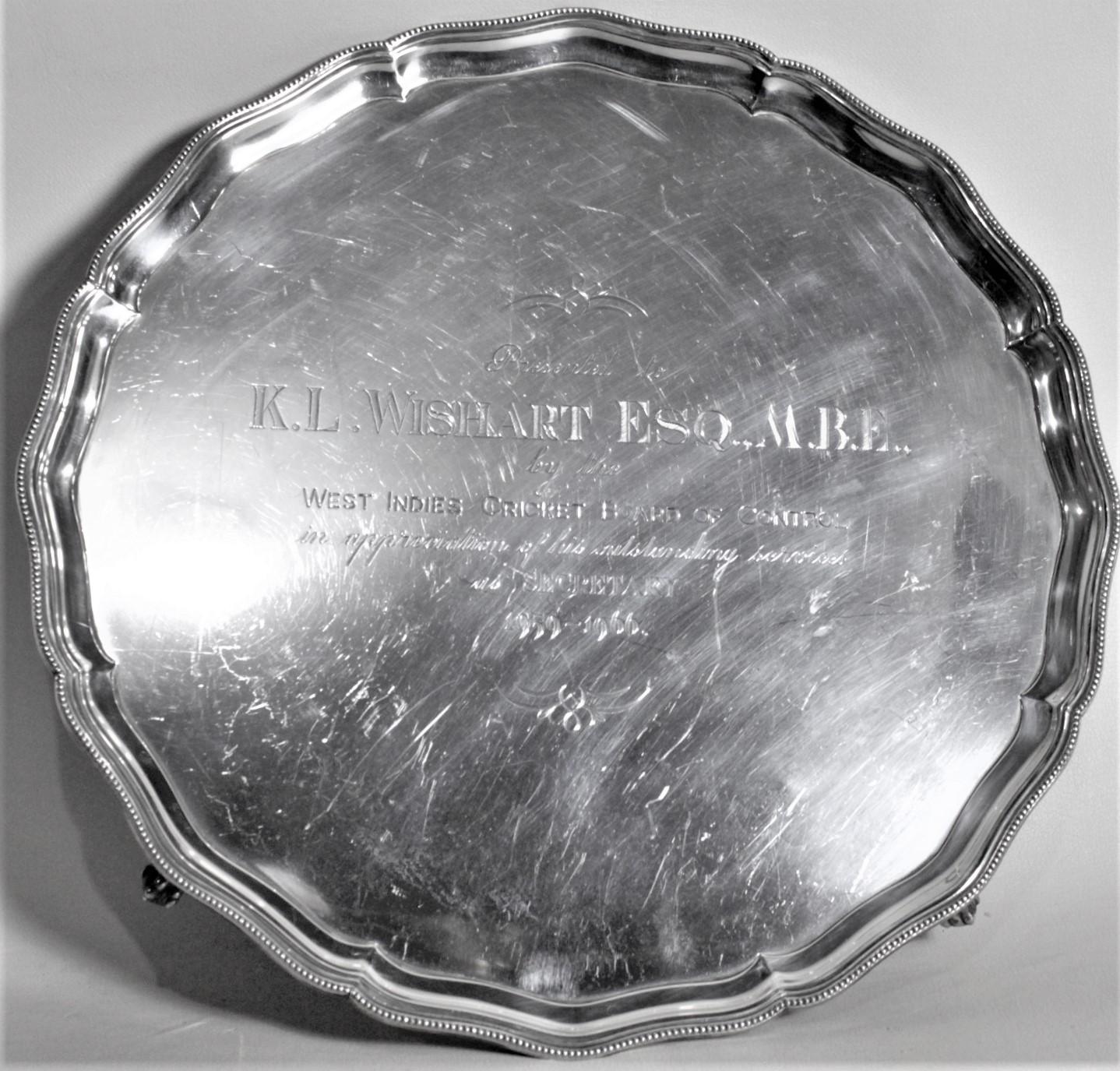 This sterling silver footed presentation tray was made by the well-known English maker, Barker Ellis in circa 1967 in an Edwardian style. The tray is circular with a pie crust edge and paw feet and is engraved on the top to a 