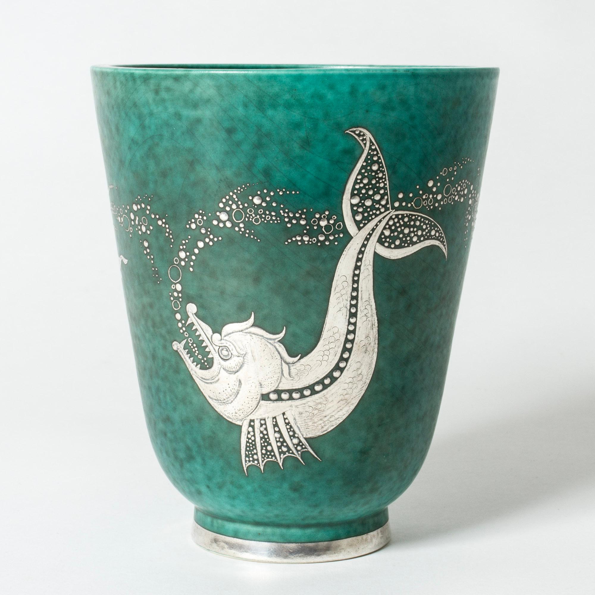 Stoneware “Argenta” vase by Wilhelm Kåge with beautiful silver decor of a big fish chasing a smaller fish, chasing a smaller fish. Lovely attention to every detail, scales and bubbles.

“Argenta” was introduced at the Stockholm exhibition in 1930
