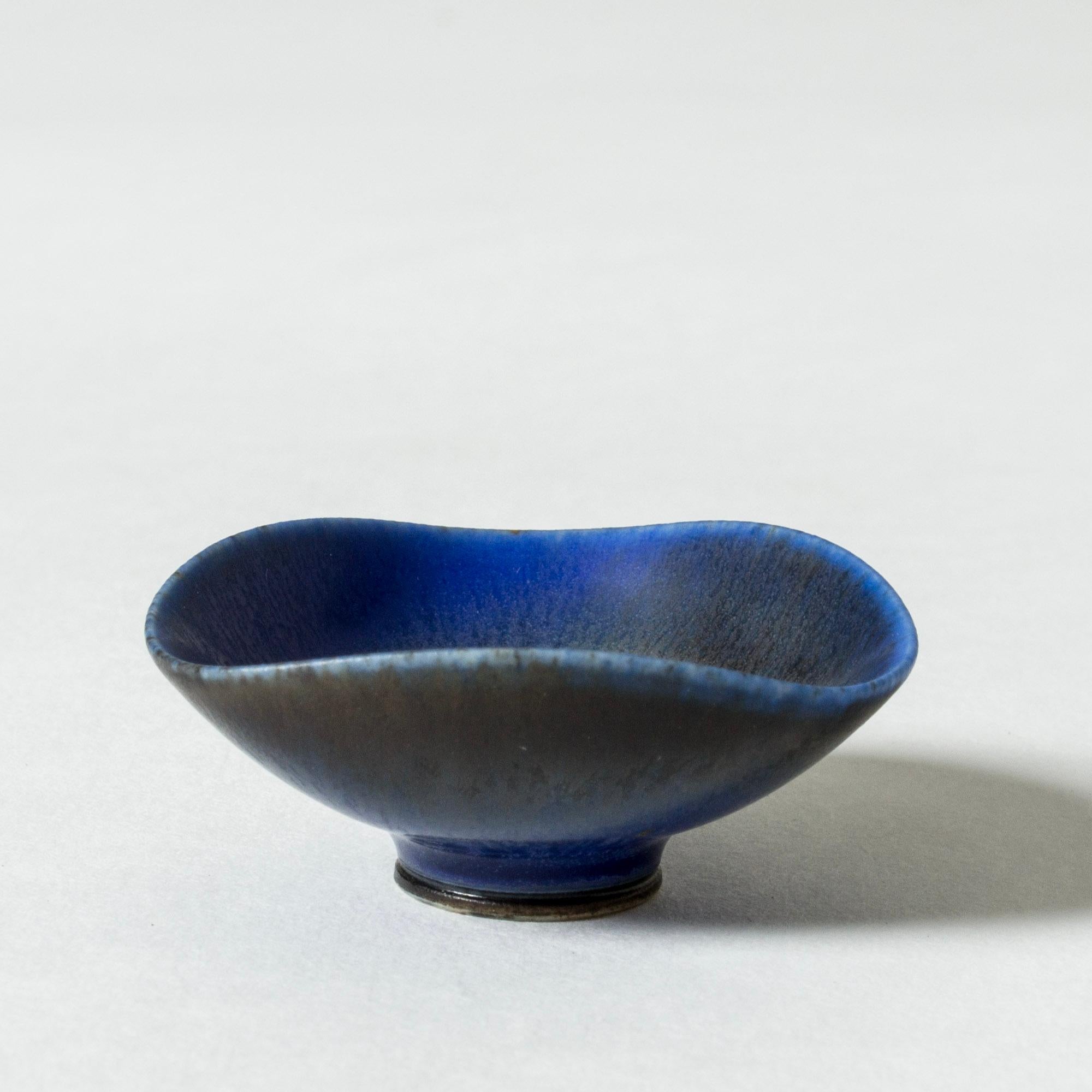 Lovely miniature stoneware bowl by Berndt Friberg. Triangular form with rounded corners, undulating edge. Elegant blue hare’s fur glaze.

Berndt Friberg was a Swedish ceramicist, renowned for his stoneware vases and vessels for Gustavsberg. His