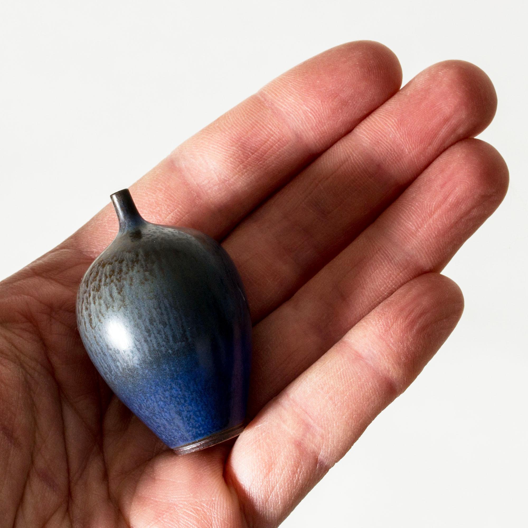 Lovely miniature stoneware vase by Berndt Friberg, in an oval form with a slender neck. Blue hare’s fur glaze with brown streaks.

Berndt Friberg was a Swedish ceramicist, renowned for his stoneware vases and vessels for Gustavsberg. His pure,
