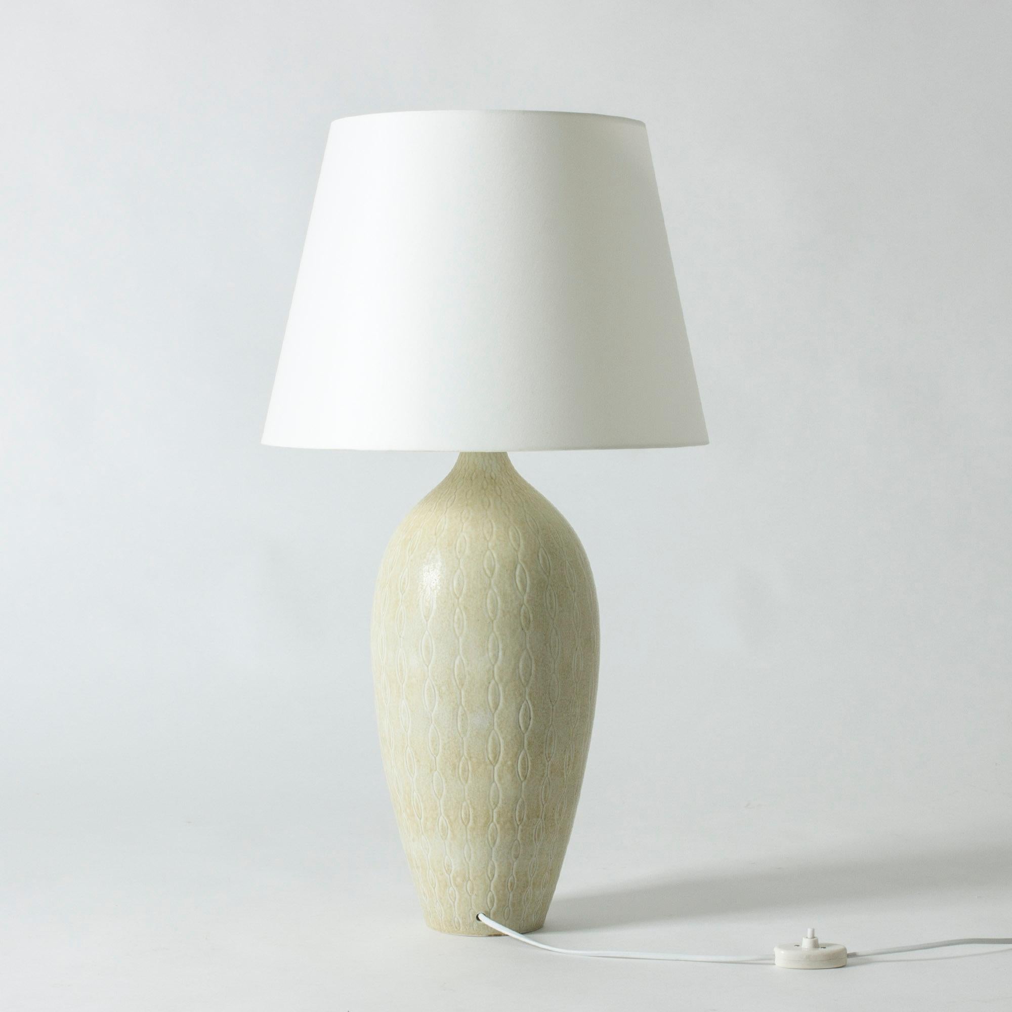 Striking, large table lamp by Carl-Harry Stålhane. Stoneware base with a beautiful wavy pattern, glazed eggshell white.