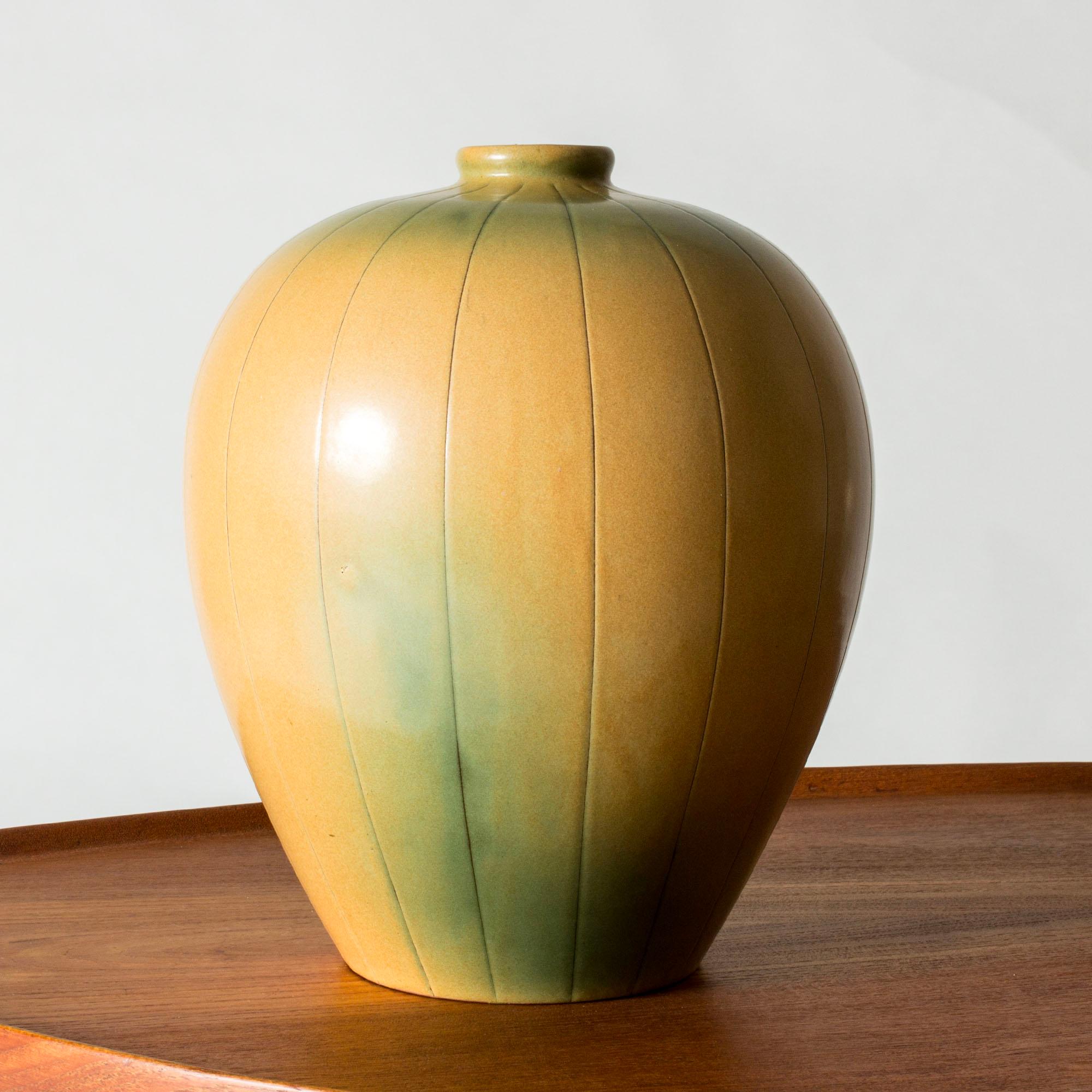 Grande vaso in terracotta di Anna-Lisa Thomson dalla forma ampia con motivo a strisce. Smalto giallo caldo con sfumature verdi.

Il vaso fa parte della serie 