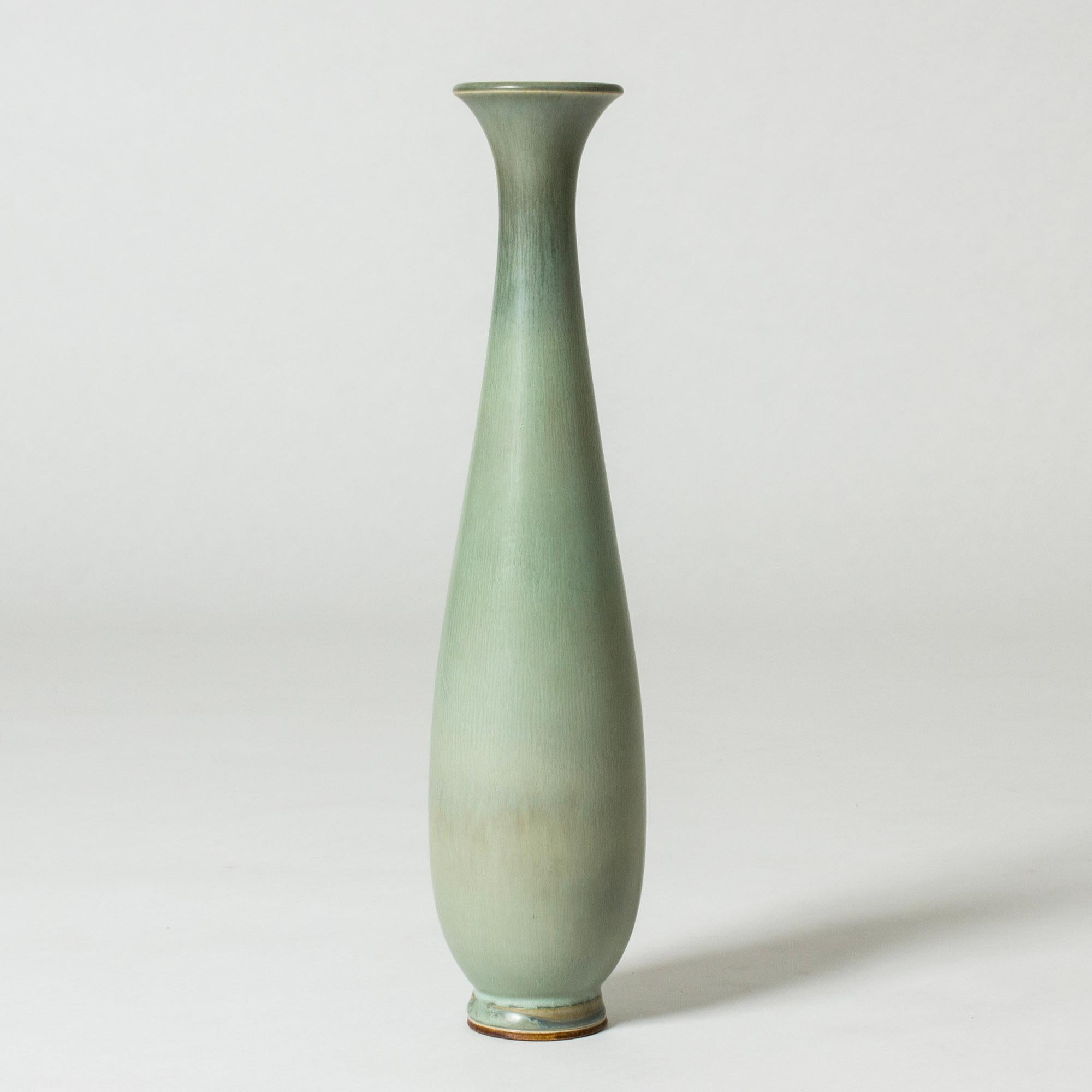 Beautiful stoneware vase by Berndt Friberg in a long elegantly curved form. Pale celadon green glaze.

Berndt Friberg was a Swedish ceramicist, renowned for his stoneware vases and vessels for Gustavsberg. His pure, composed designs with satiny,