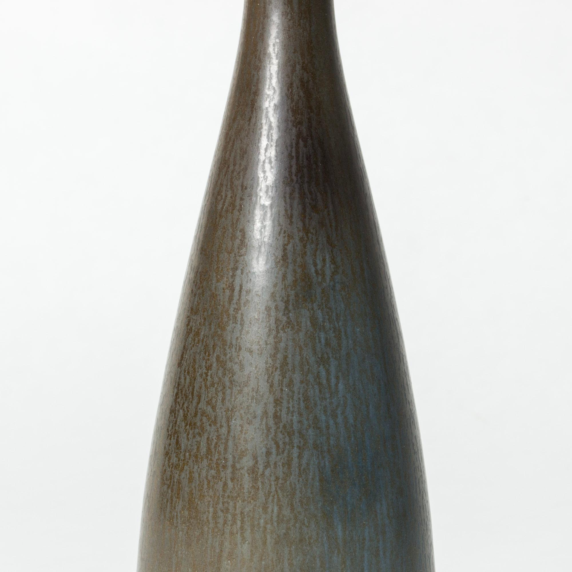 Stoneware vase by Berndt Friberg in an elegant form with a slightly angular silhouette. Dark blue hare’s fur glaze with brownish tones.

Berndt Friberg was a Swedish ceramicist, renowned for his stoneware vases and vessels for Gustavsberg. His pure,