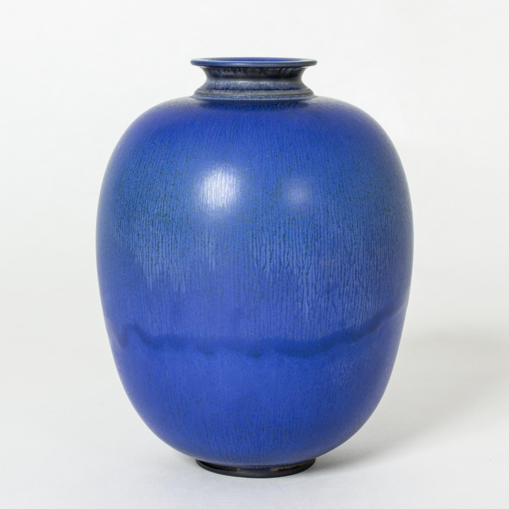 Beautiful stoneware vase by Berndt Friberg, in an oval, plump form. Vibrant blue hare’s fur glaze, paler on the top half of the body.

Berndt Friberg was a Swedish ceramicist, renowned for his stoneware vases and vessels for Gustavsberg. His pure,