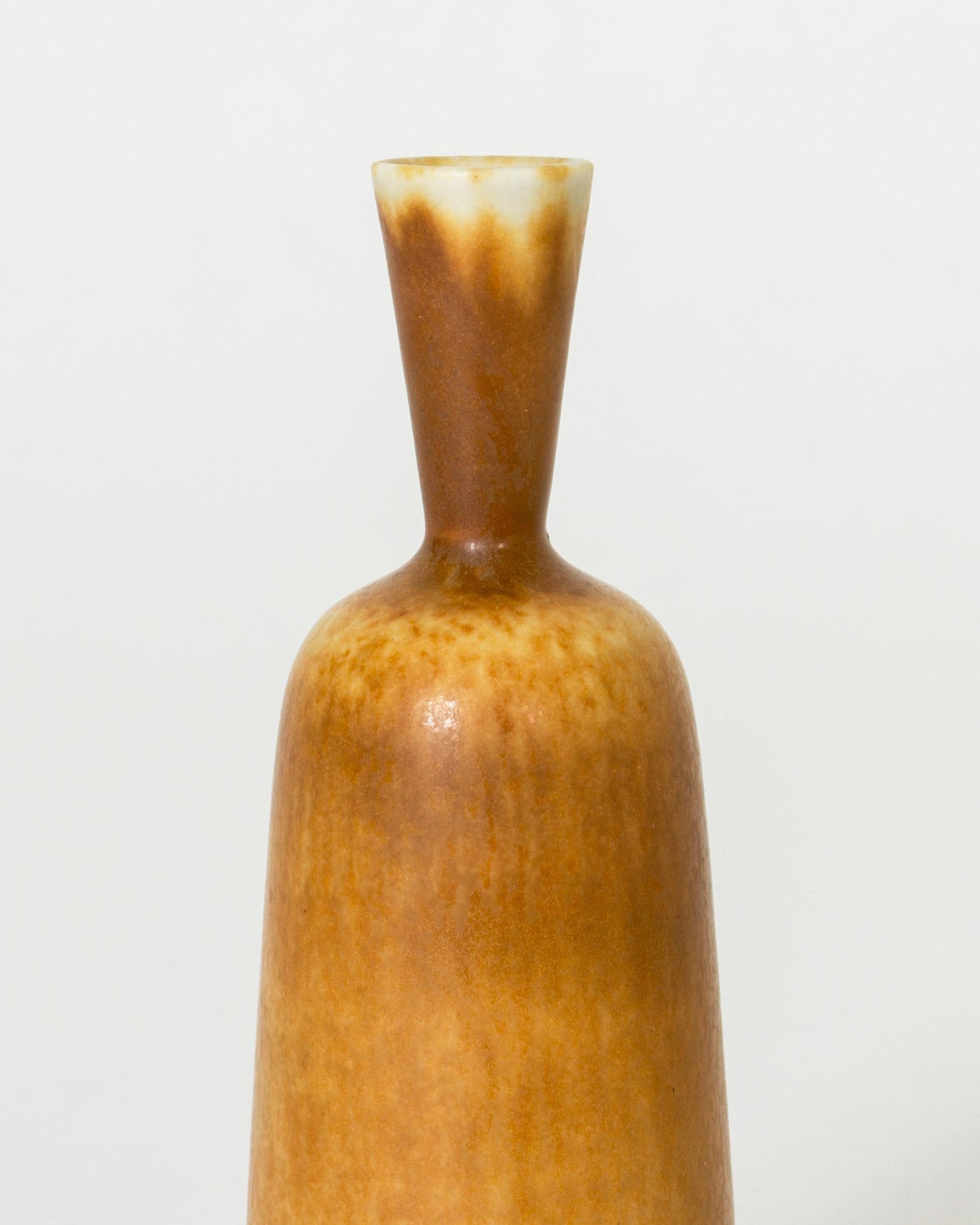 Tiny stoneware vase by Berndt Friberg, in a slender form with light brown and ochre hare’s fur glaze.

Berndt Friberg was a Swedish ceramicist, renowned for his stoneware vases and vessels for Gustavsberg. His pure, composed designs with satiny,