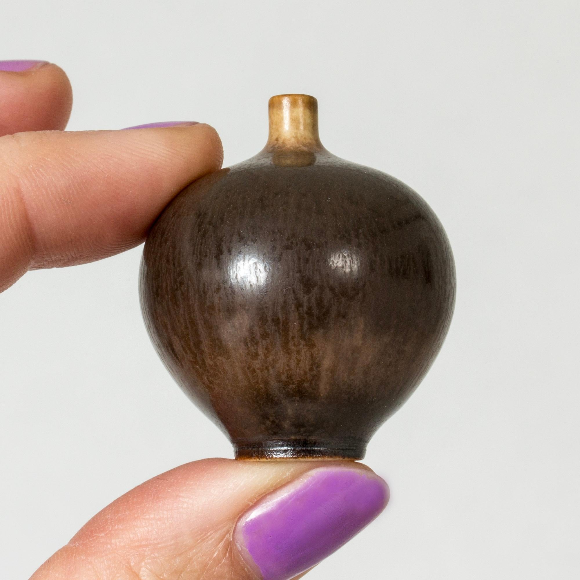 Miniature stoneware vase by Berndt Friberg in a rare, tiny size. Round form with dark brown somewhat glossy hare’s fur glaze.

Berndt Friberg was a Swedish ceramicist, renowned for his stoneware vases and vessels for Gustavsberg. His pure, composed