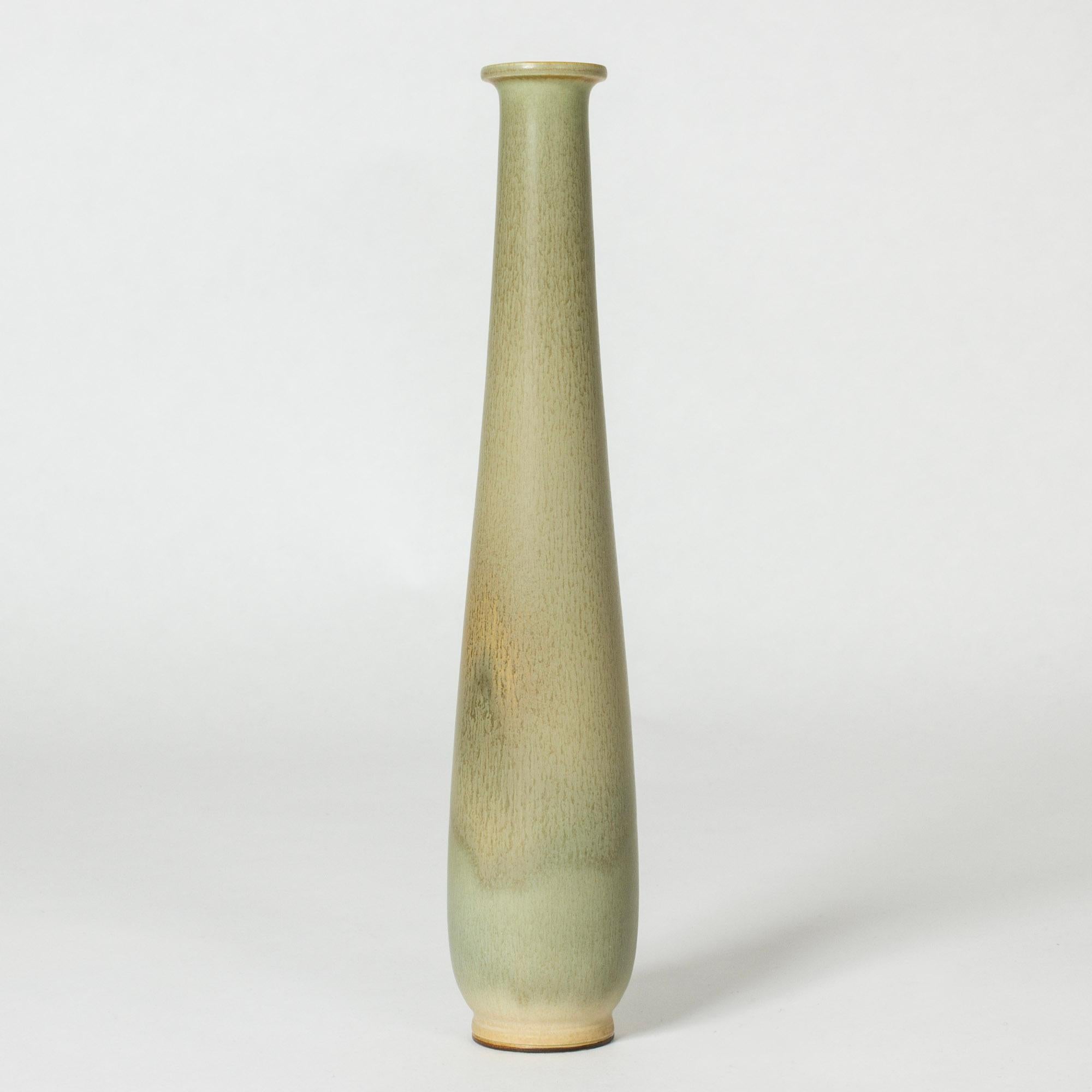 Stoneware vase by Berndt Friberg in a long elegantly streamlined form. Pale celadon green glaze with rusty flecks.

Berndt Friberg was a Swedish ceramicist, renowned for his stoneware vases and vessels for Gustavsberg. His pure, composed designs