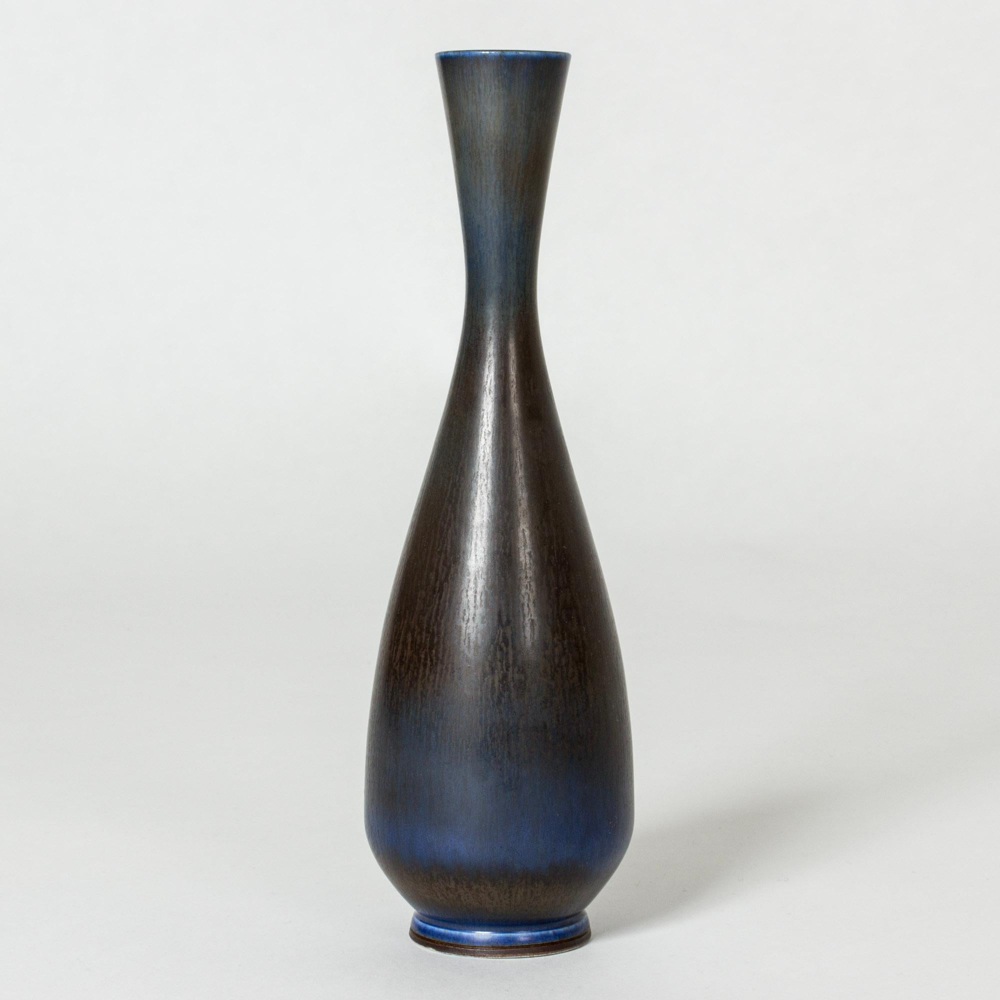 Stoneware vase by Berndt Friberg in a smooth form with some angularity. Vibrant dark blue hare’s fur glaze blending into dark brown.

Berndt Friberg was a Swedish ceramicist, renowned for his stoneware vases and vessels for Gustavsberg. His pure,