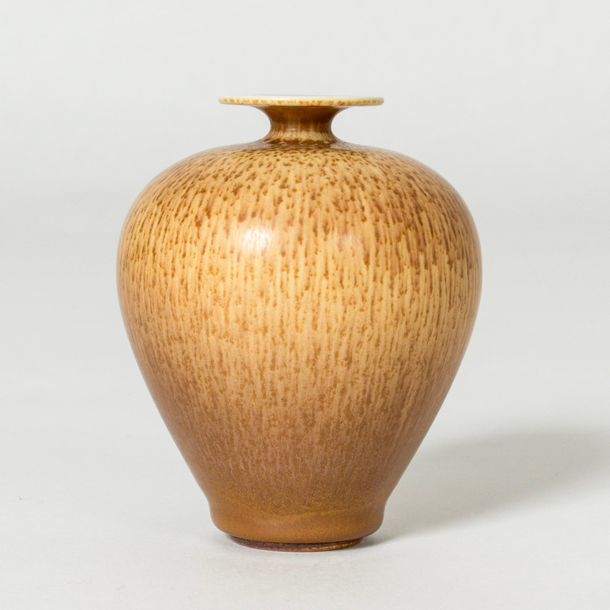 Beautiful, small stoneware vase by Berndt Friberg, in a plump form with distinct hare’s fur glaze in warm brown on caramel nuances.

Berndt Friberg was a Swedish ceramicist, renowned for his stoneware vases and vessels for Gustavsberg. His pure,