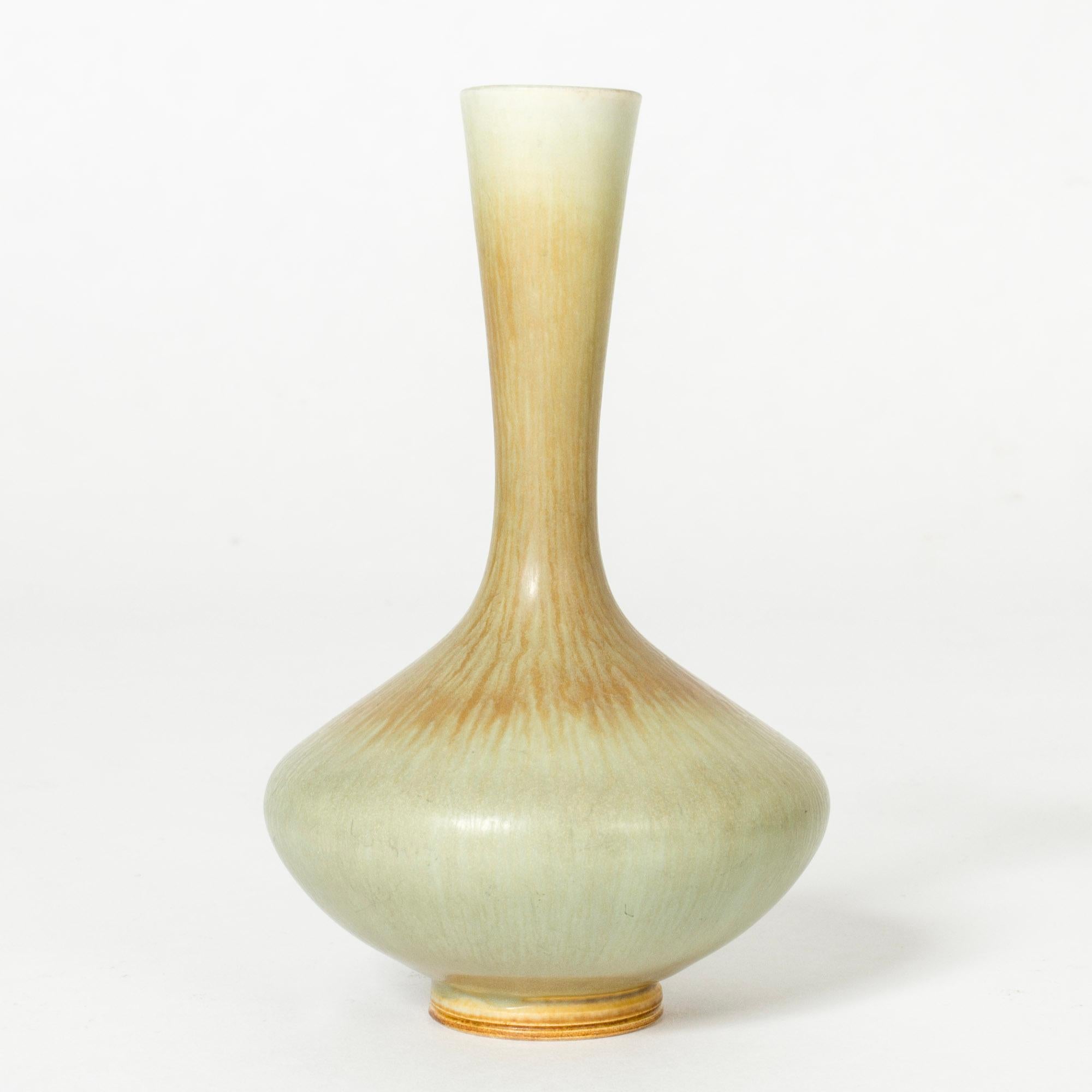 Lovely stoneware vase by Berndt Friberg, with a slender neck and plump base. Glazed pale celadon green with warm brown streaks.

Berndt Friberg was a Swedish ceramicist, renowned for his stoneware vases and vessels for Gustavsberg. His pure,