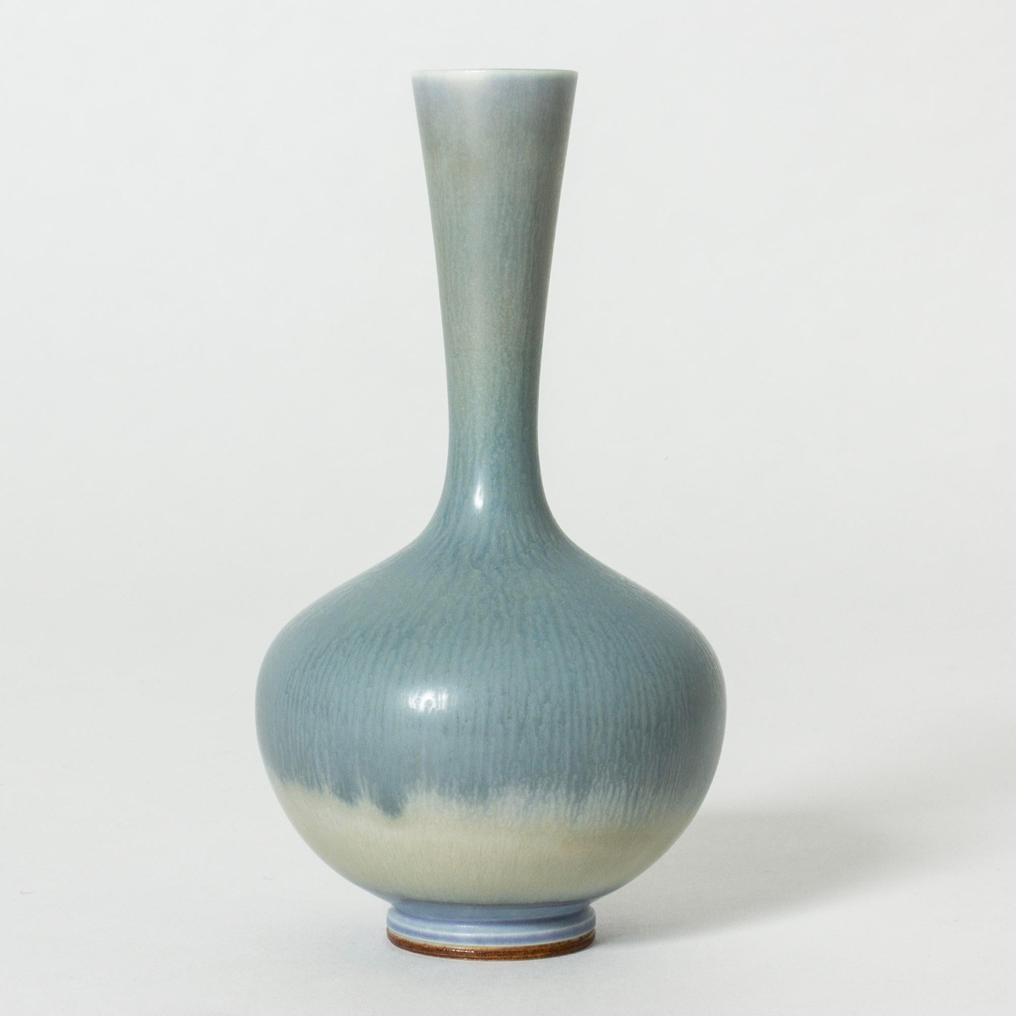 Hübsche Steinzeugvase von Berndt Friberg mit schlankem Hals und prallem, zwiebelförmigem Boden. Himmelblau mit Übergang zu weißer Hasenfellglasur.

Berndt Friberg war ein schwedischer Keramiker, der für seine Steinzeugvasen und -gefäße für