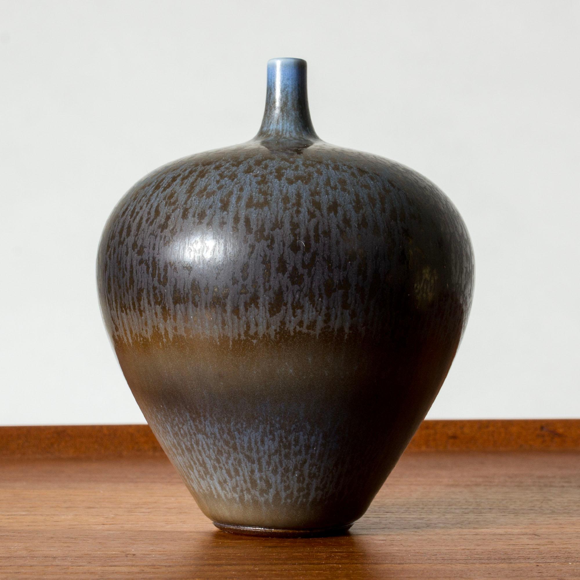 Piccolo vaso in gres di Berndt Friberg, dall'ampia forma di mela e dal collo sottile. Decorato con smalto di pelliccia di lepre blu scuro con sfumature marroni.

Berndt Friberg era un ceramista svedese, famoso per i suoi vasi e recipienti in gres
