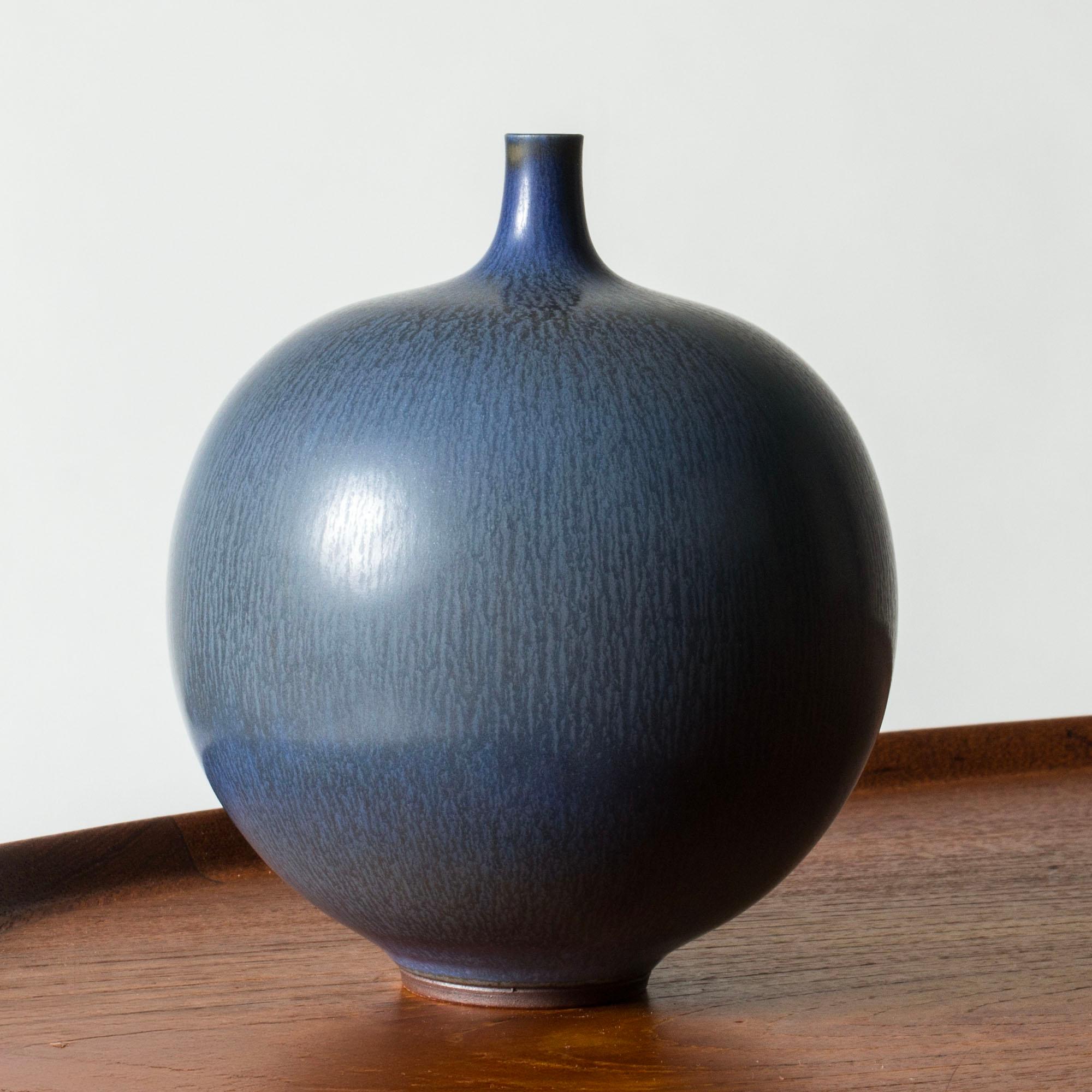 Bellissimo vaso in gres di Berndt Friberg, dall'accattivante forma rotonda e dal collo sottile. Smalto blu a pelo di lepre con striature più scure.

Berndt Friberg era un ceramista svedese, famoso per i suoi vasi e recipienti in gres per