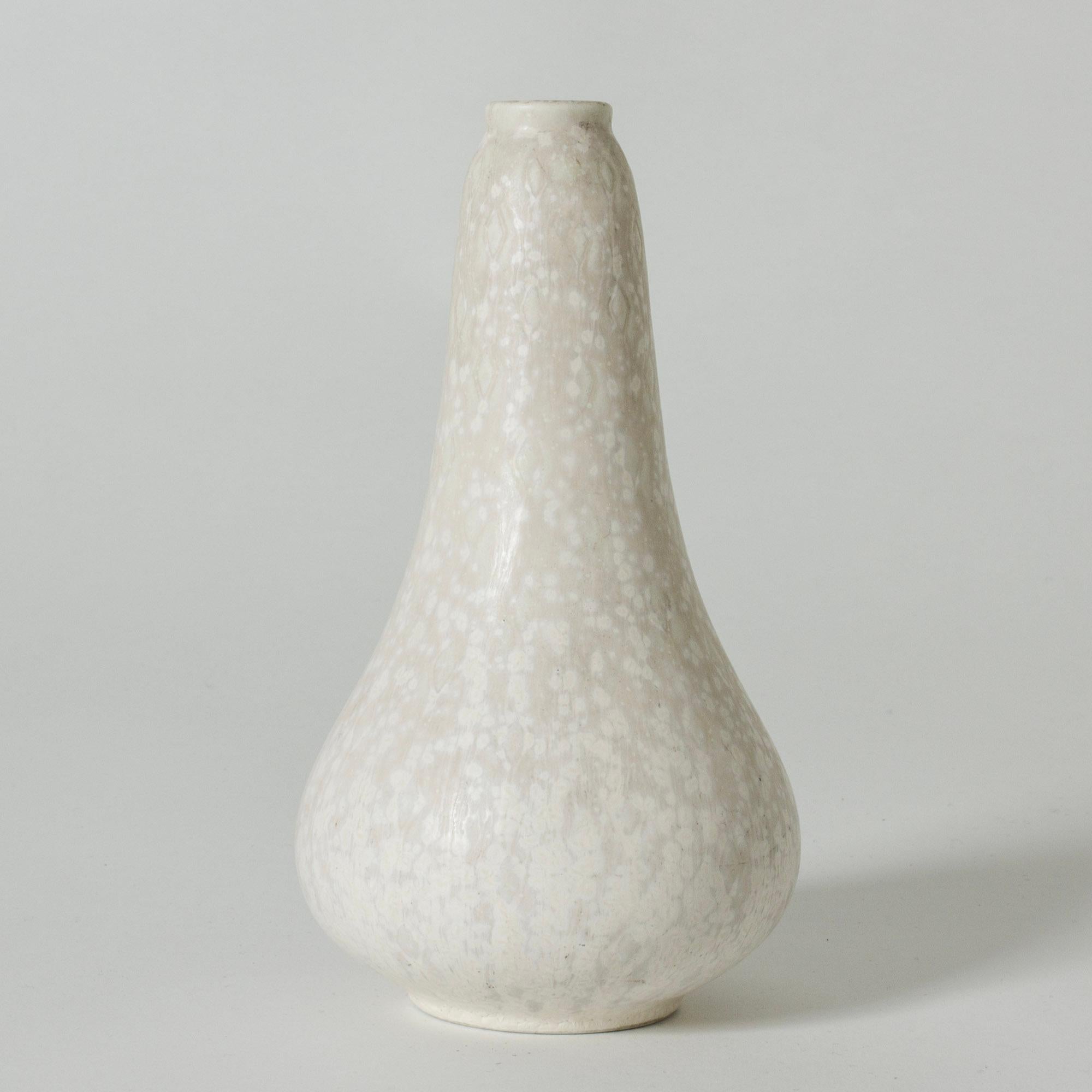 Neat stoneware vase by Gunnar Nylund, in a drop form. Glazed eggshell white over a subtle graphic pattern.

Gunnar Nylund was one of the most influential ceramicists and designers of the Swedish mid-century period. He was Rörstrand’s creative