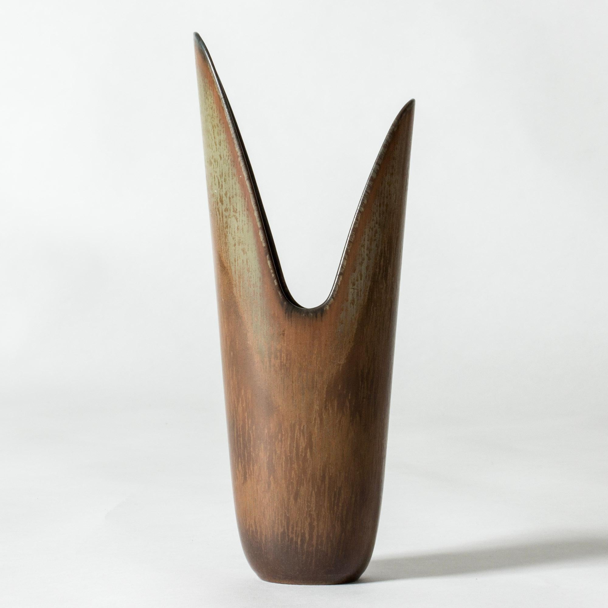 Striking stoneware vase by Gunnar Nylund, in a bold asymmetric form, sometimes called the Nylund “Pike” vase. Brown and greenish glaze in an organic pattern.

Gunnar Nylund was one of the most influential ceramicists and designers of the Swedish