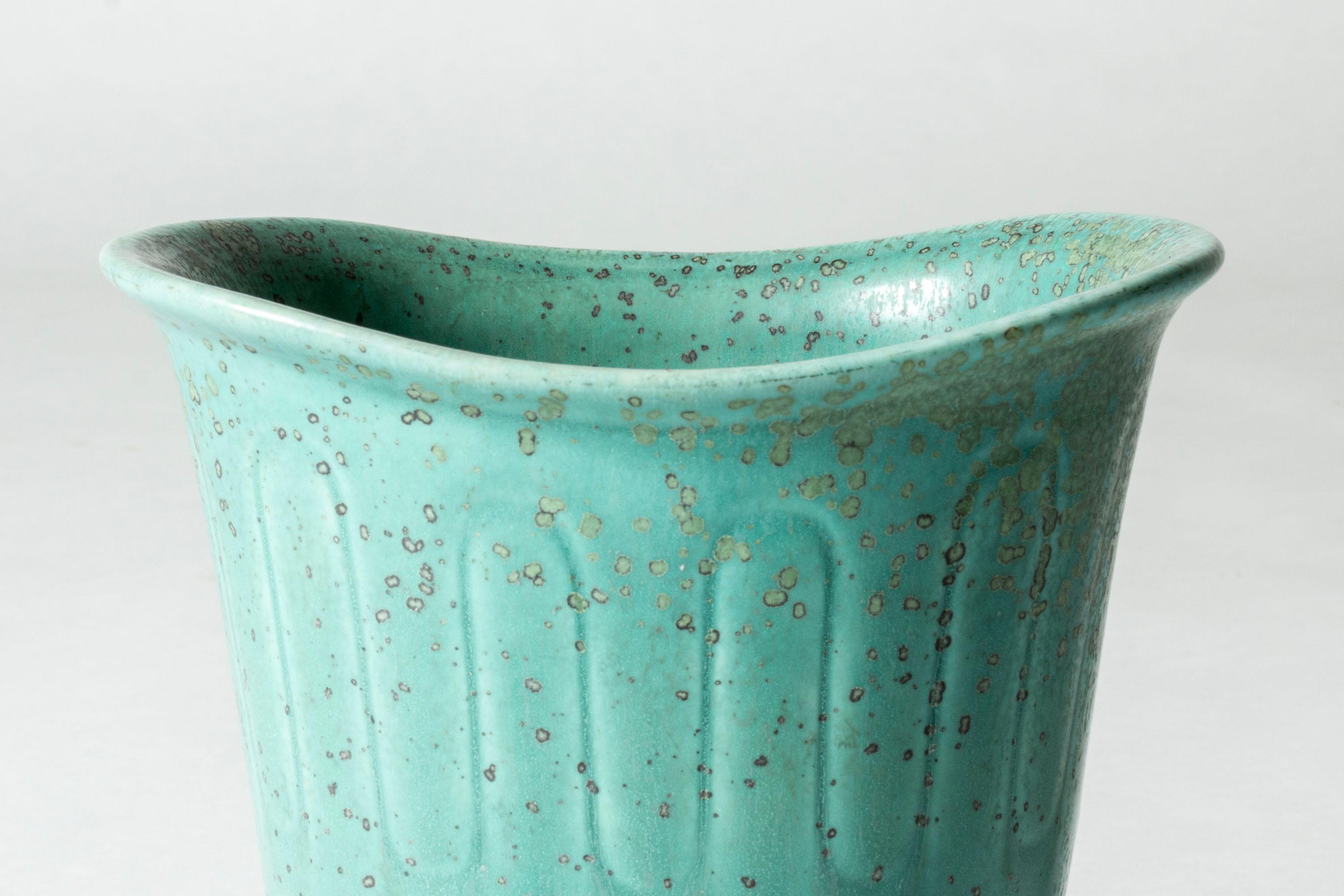 Magnifique vase en grès de Gunnar Nylund, de forme effilée avec une large ouverture, parfait pour les fleurs. Motif graphique gaufré avec glaçure vert célodon et mouchetures 