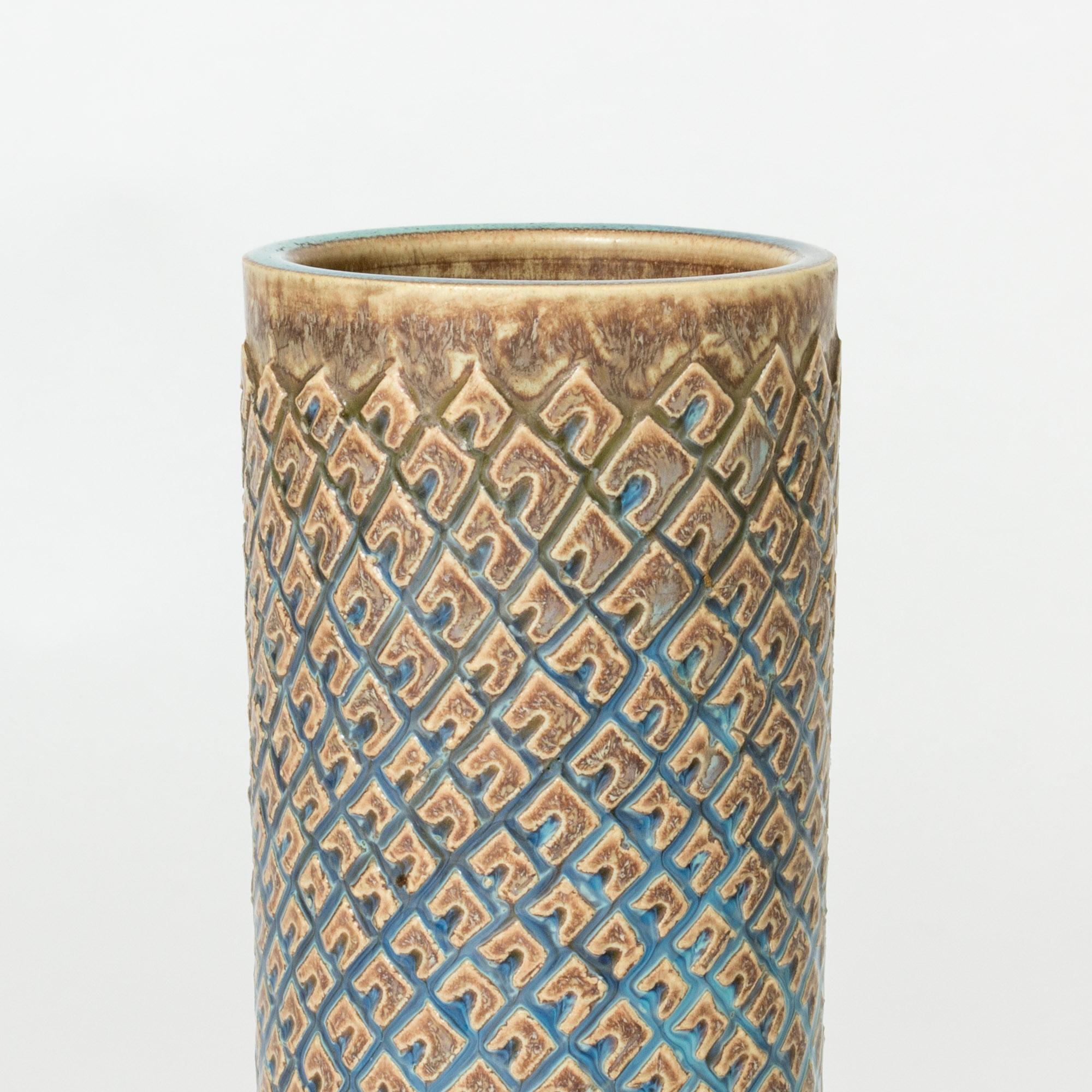 Striking stoneware vase by Stig Lindberg, in a cylinder form. Graphic pattern with blue and sand colored glaze.