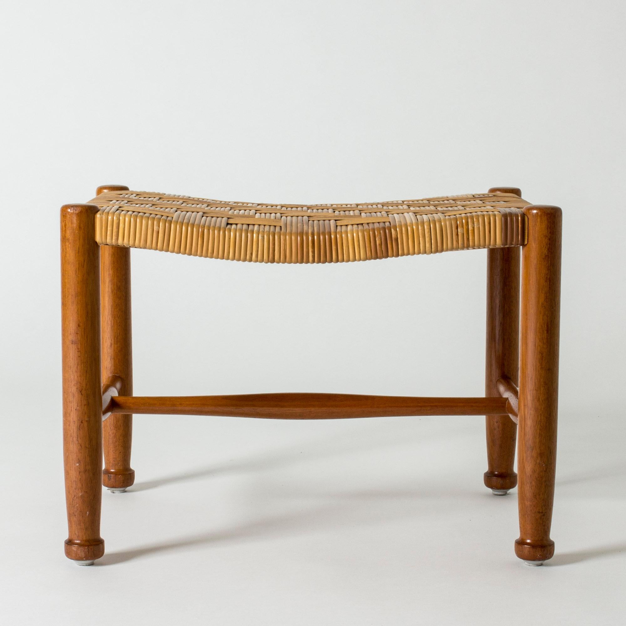 Neat stool by Josef Frank, made from mahogany with elegantly sculpted feet. Rattan seat in a densely wreathed pattern.
