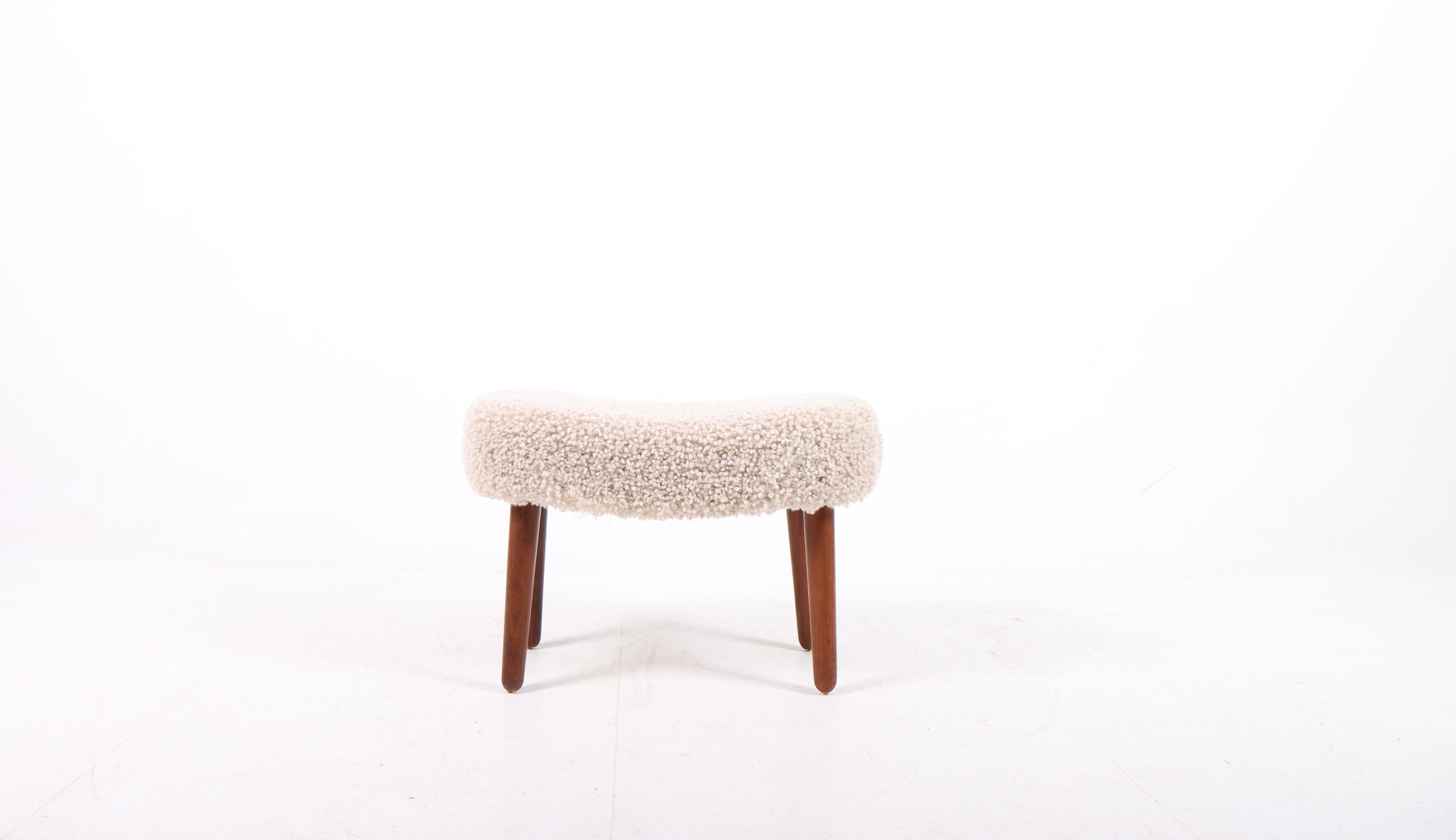 Ottoman remeublé avec de la peau de mouton. Conçu par les architectes danois Ib Madsen & Acton Schubell. Excellent état.