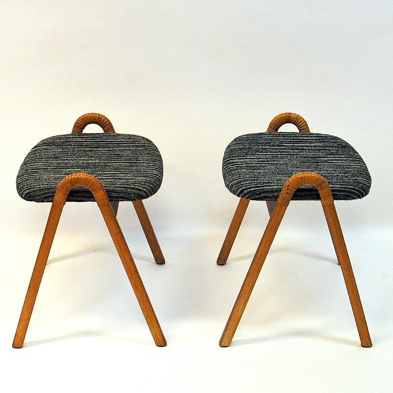 Lovely pair of vintage stools with original seat fabric and rattan handles produced by Møre Lenestolfabrikk, 1950s, Norway. Original black/beige striped cushions and lovely sculped side handles. Great pair of stools perfect as extra chairs or