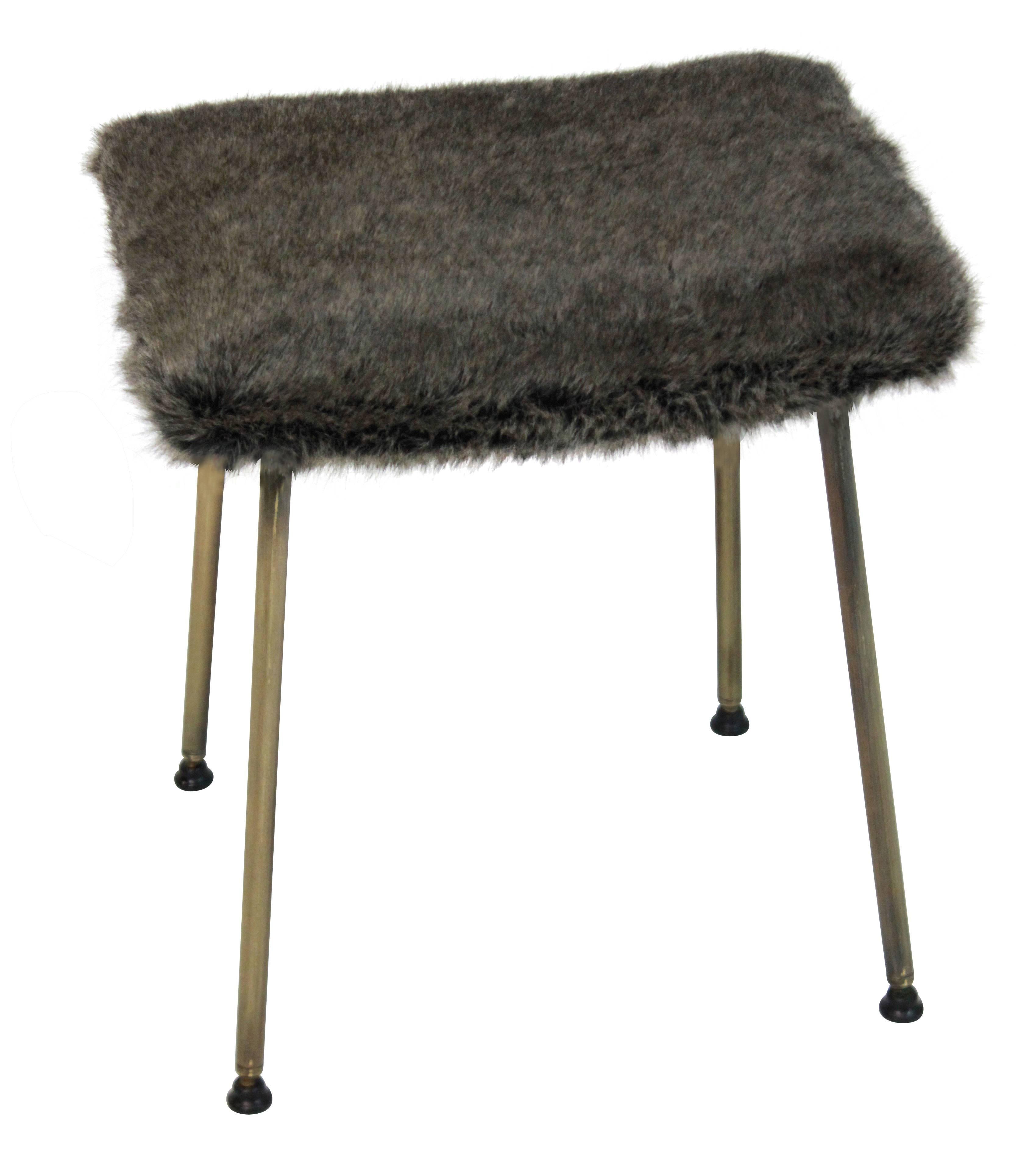 An English midcentury stool on brass legs with a faux fur seat.
