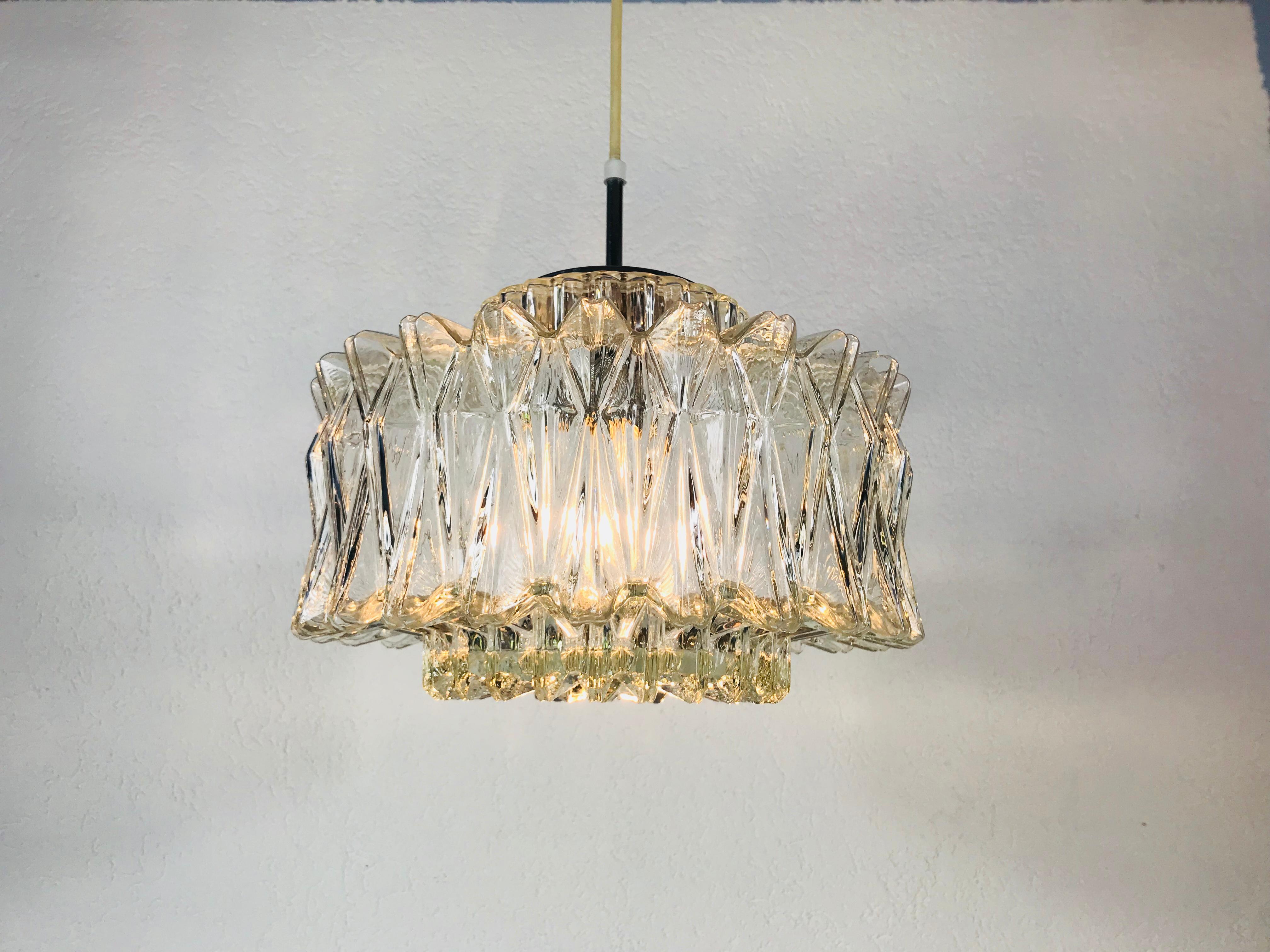 A Mid-Century Modern chandelier by Glashütte Limburg made in the 1960s in Germany. It is fascinating with its beautiful diamond shape. 3-tier structured glass with chrome aluminum top.

The light requires one E27 light bulb.