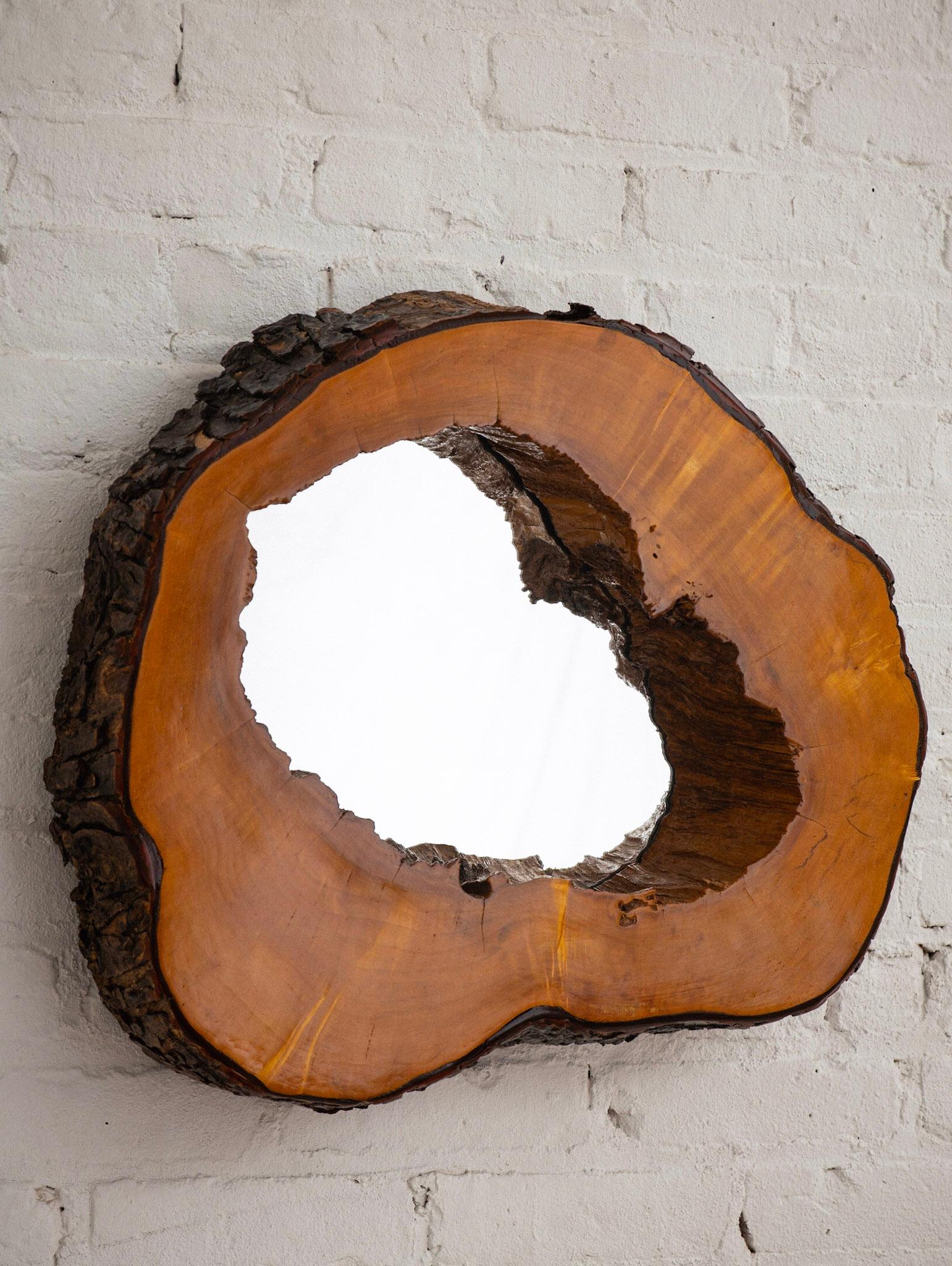 Mid-century studio made mirror. Live edge wood with a lacquered finish. A hollowed log slice has been used to create the frame around the mirror. Original natural bark on outer edges.
