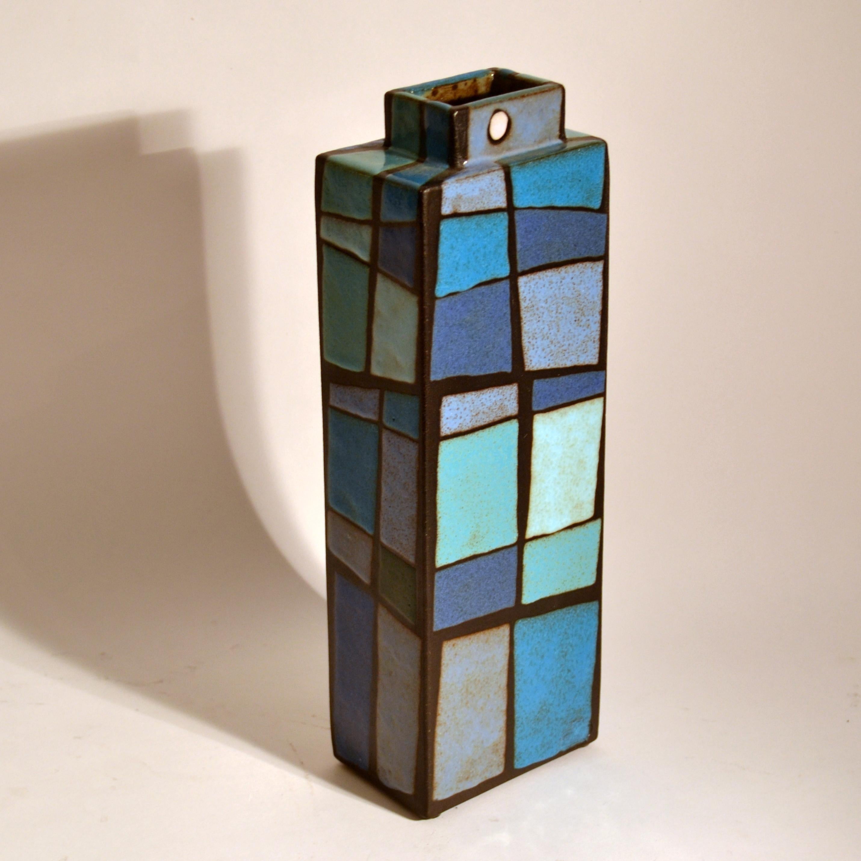 Rectangular studio pottery vase with a pattern in multi tones of blue and turquoise applied in blocks of colour on nearly black earthenware, signed Swano.