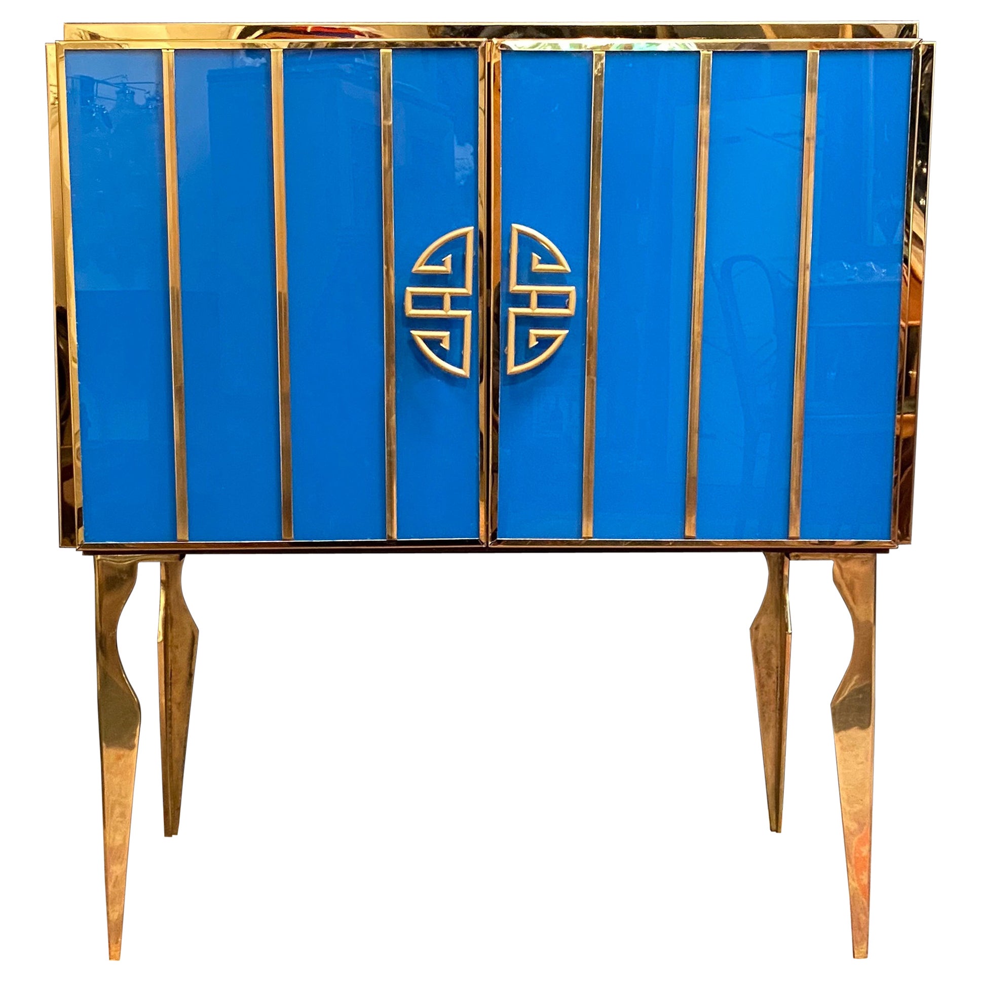 Very fine handmade bar cabinet by a master artisan. Brass frame with handmade and hand-cut cobalt blue and white opaline Murano glass raised on special brass legs.
Offered separately or as a pair. Listed price is for one item.