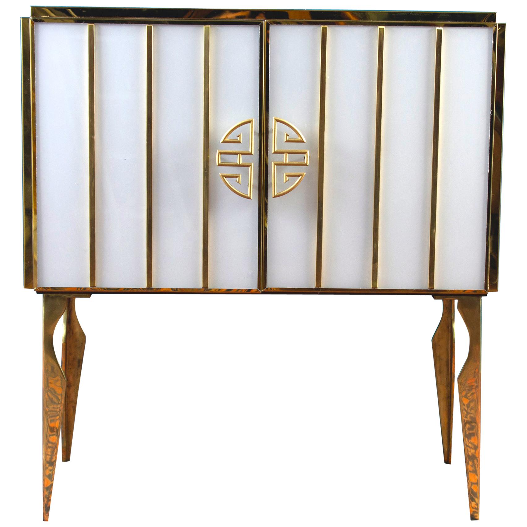 Very fine handmade bar cabinet by a master artisan. Brass frame with handmade and handcut cobalt blue and white opaline Murano glass raised on special brass legs.
Offered separately or as a pair. Listed price is for one item.