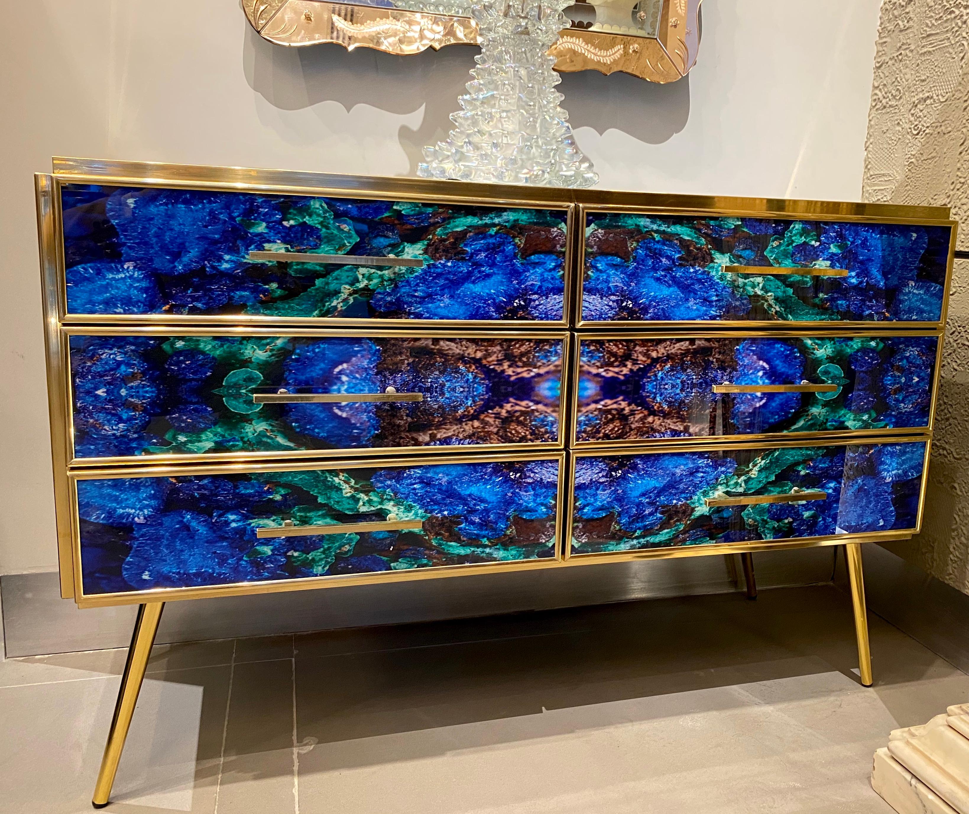 Striking brass frame and handcut Lapis lazuli imitation Murano glass Commode or chest of drawer, raised on special brass legs. 
Handmade by a master artisan.
 Available also the pair.