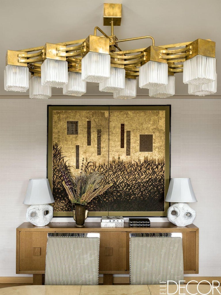 This contemporary Italian brass and white Murano square glass chandelier is comprised of a linear solid brass 11-arm frame featuring square, ridged, hand casted translucent white cube glass shades. Excellent craftsmanship and attention to detail.