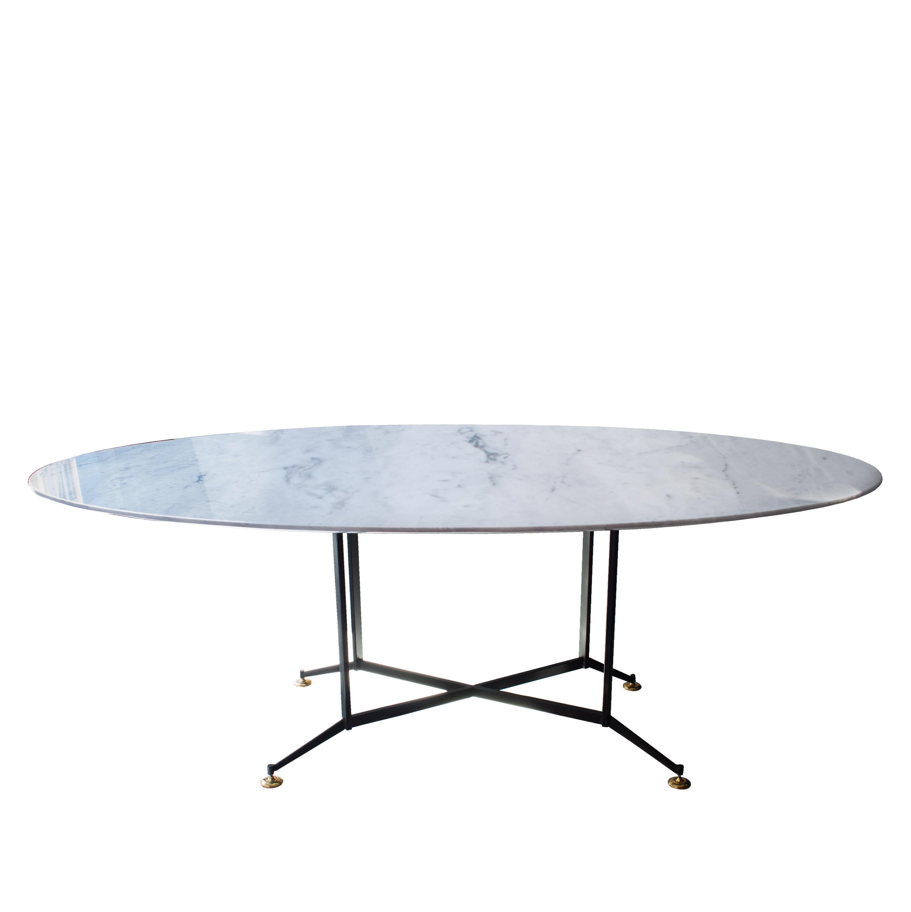 Dining table made up of black lacquered iron structure, with height adjustable brass finished legs; and oval Carrara marble top.